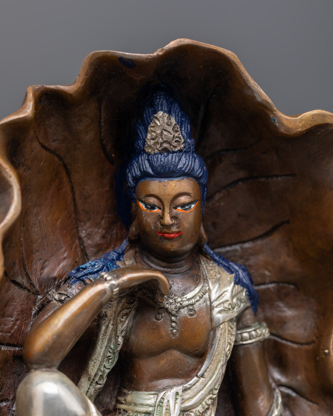 Lokiteshvara’s serene face is adorned with, highlighting craftsmanship.