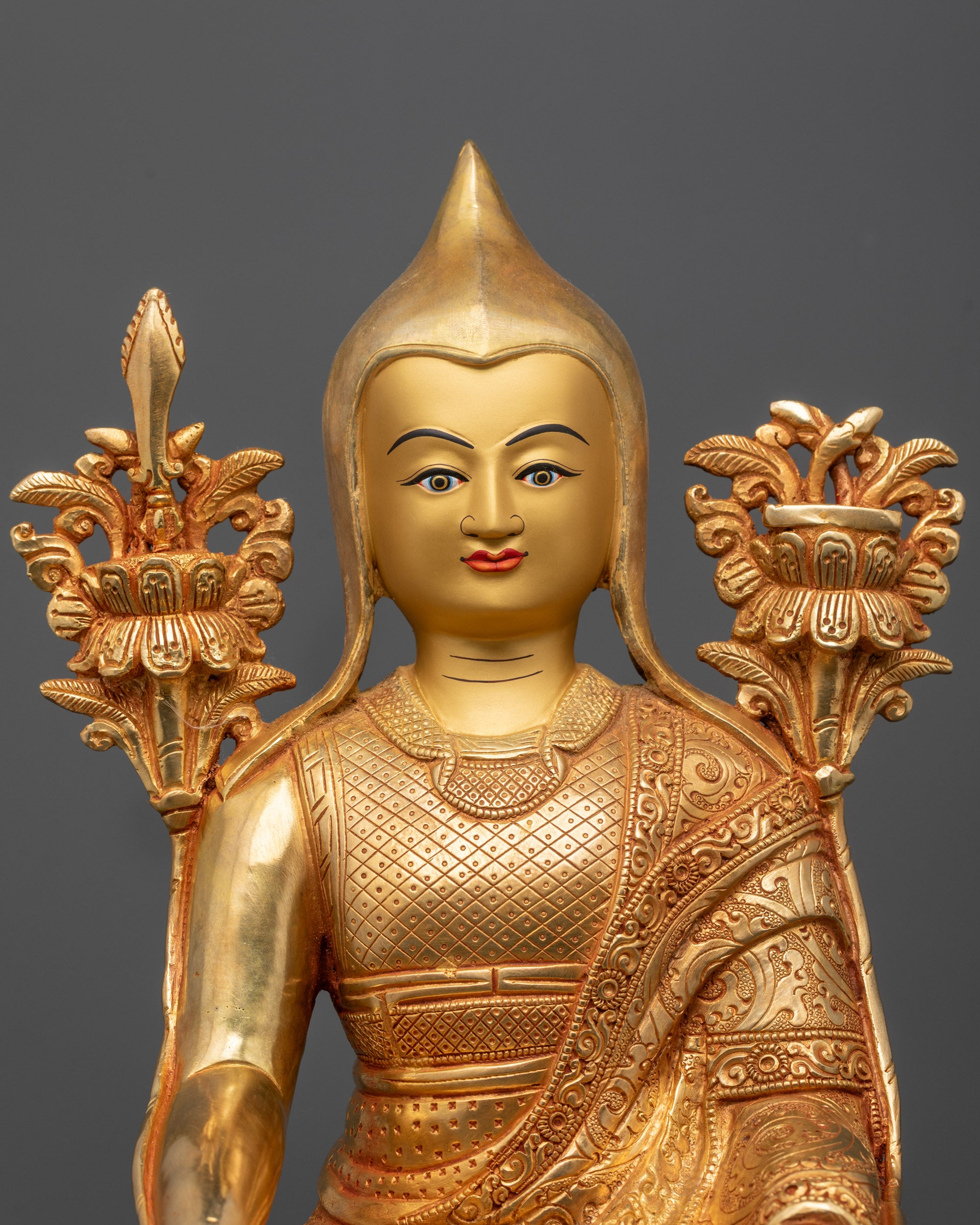 Close-up of Longchenpa Statue face and hands holding utpala flowers