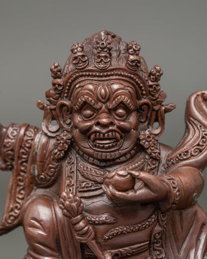 Close-up of Mahakala Bernagchen face and flaying knife detailing in chemically oxidized brown finish