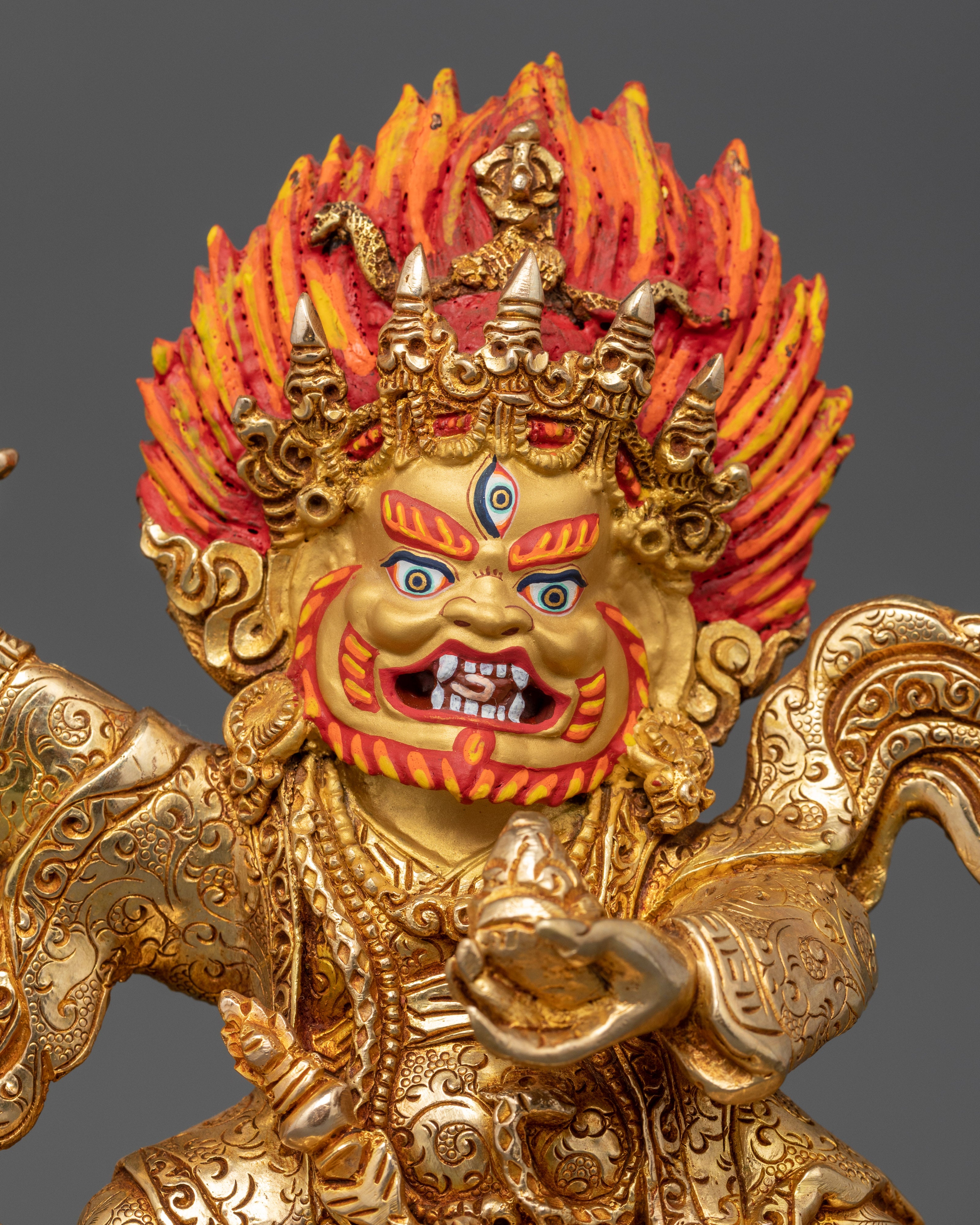 Close-up of Mahakala Bernagchen face with 24K gold-painted features and blazing halo