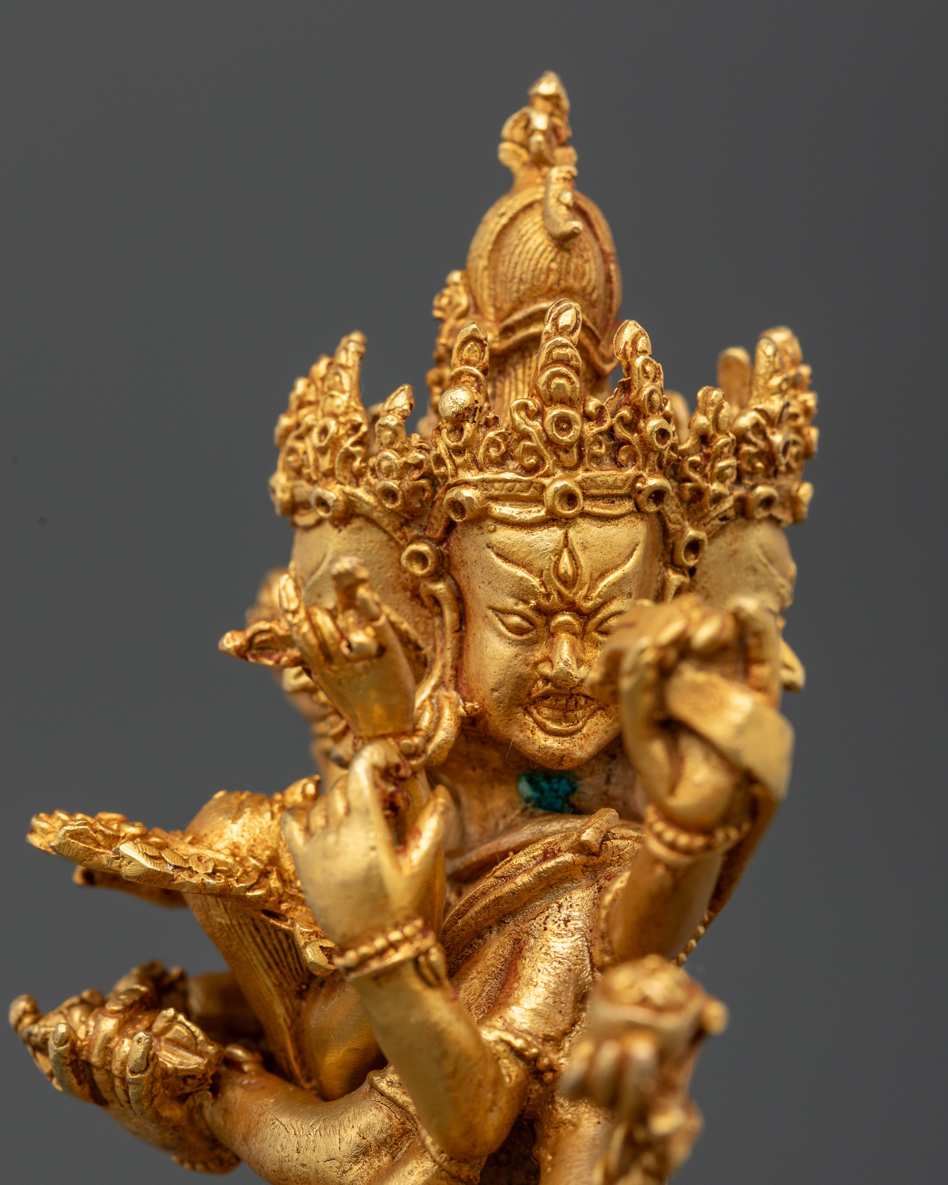 Close-up of Mahakala Bernagchen statue showing twelve arms and sacred implements on lotus seat
