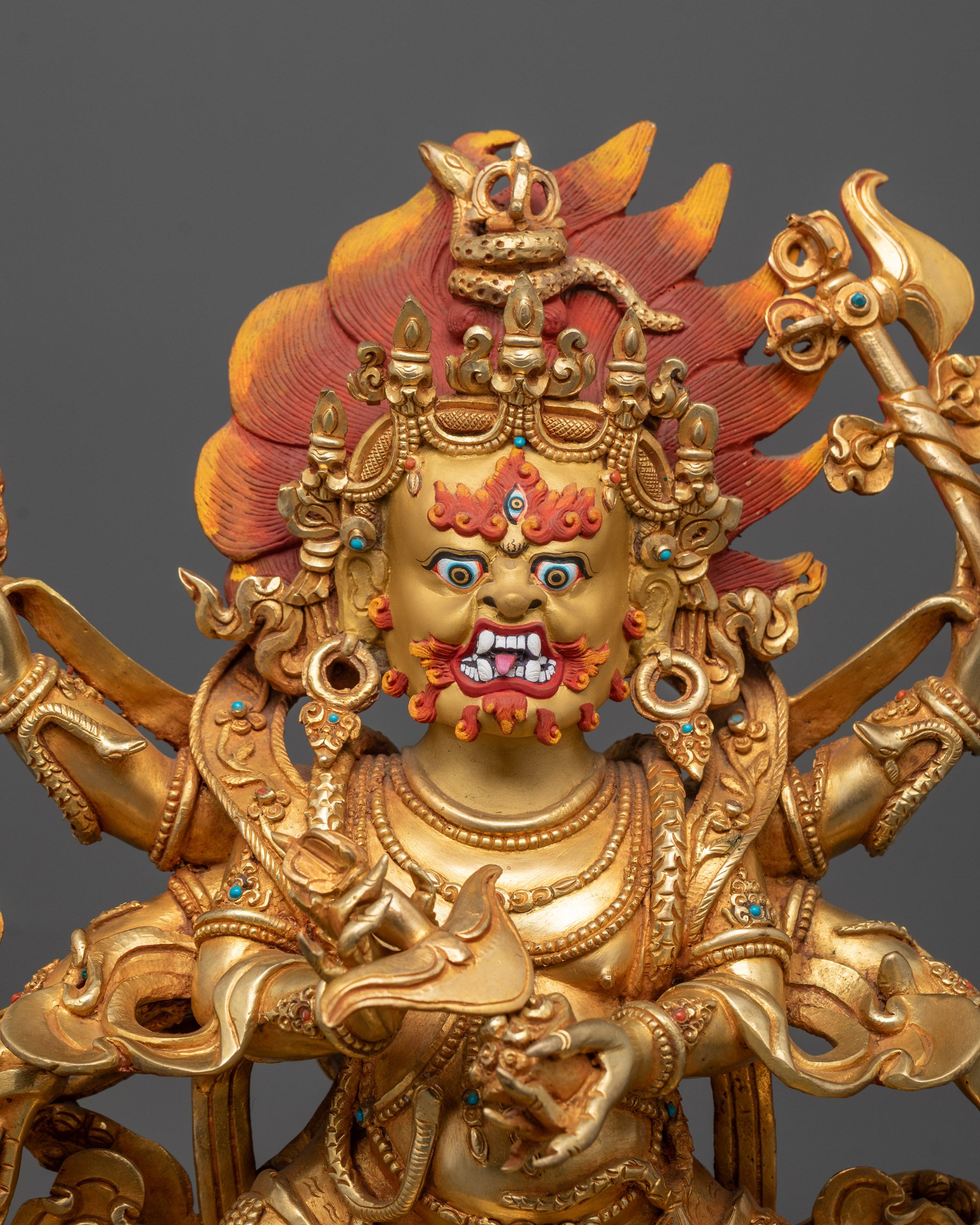 Close-up of Mahakala’s three-eyed face wearing a crown of five skulls, symbolizing transformation