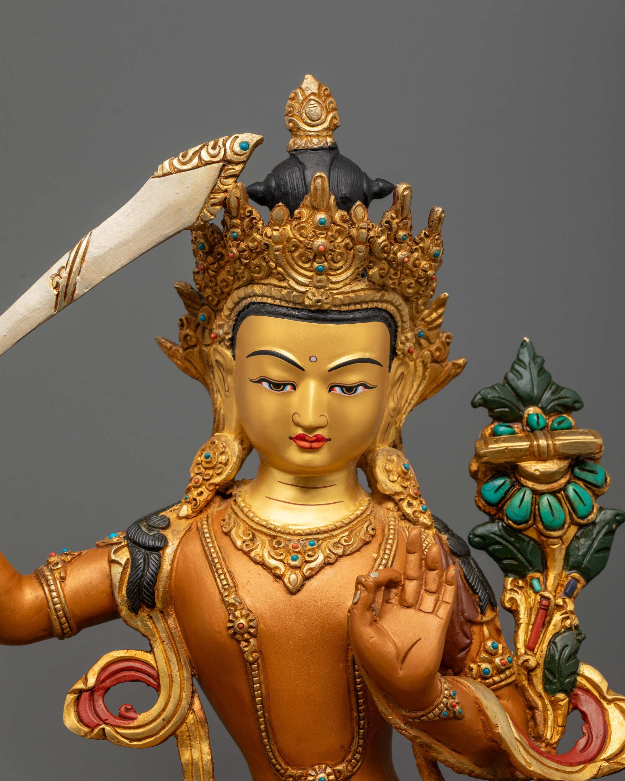 Close-up of Manjushri Bodhisattva holding flaming sword and utpala flower