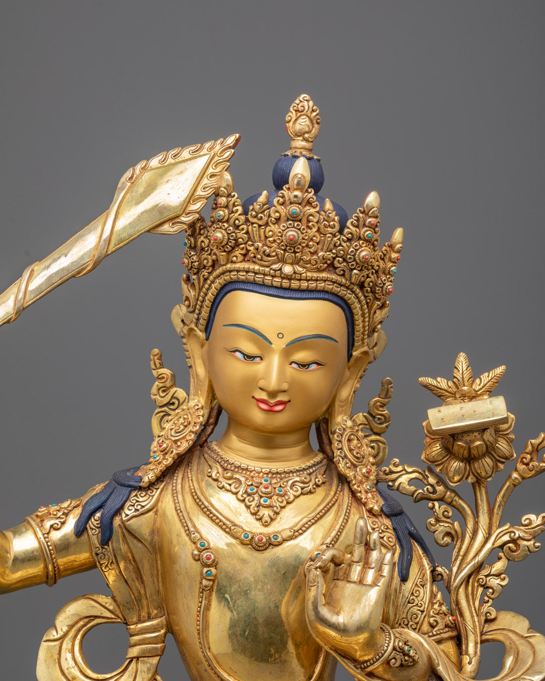 Manjushri Bodhisattva’s serene face with traditional Nepalese craftsmanship and gold accents.