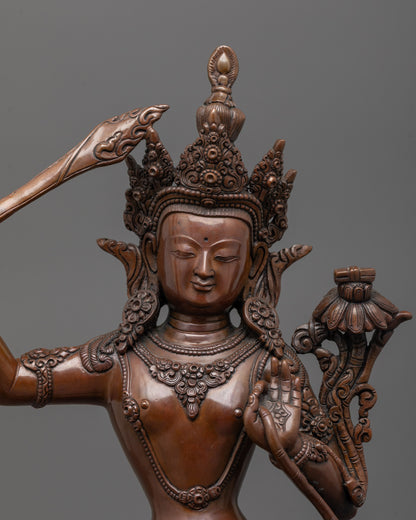 Close-up of Manjushri Statue face with oxidized copper finish and fine detailing