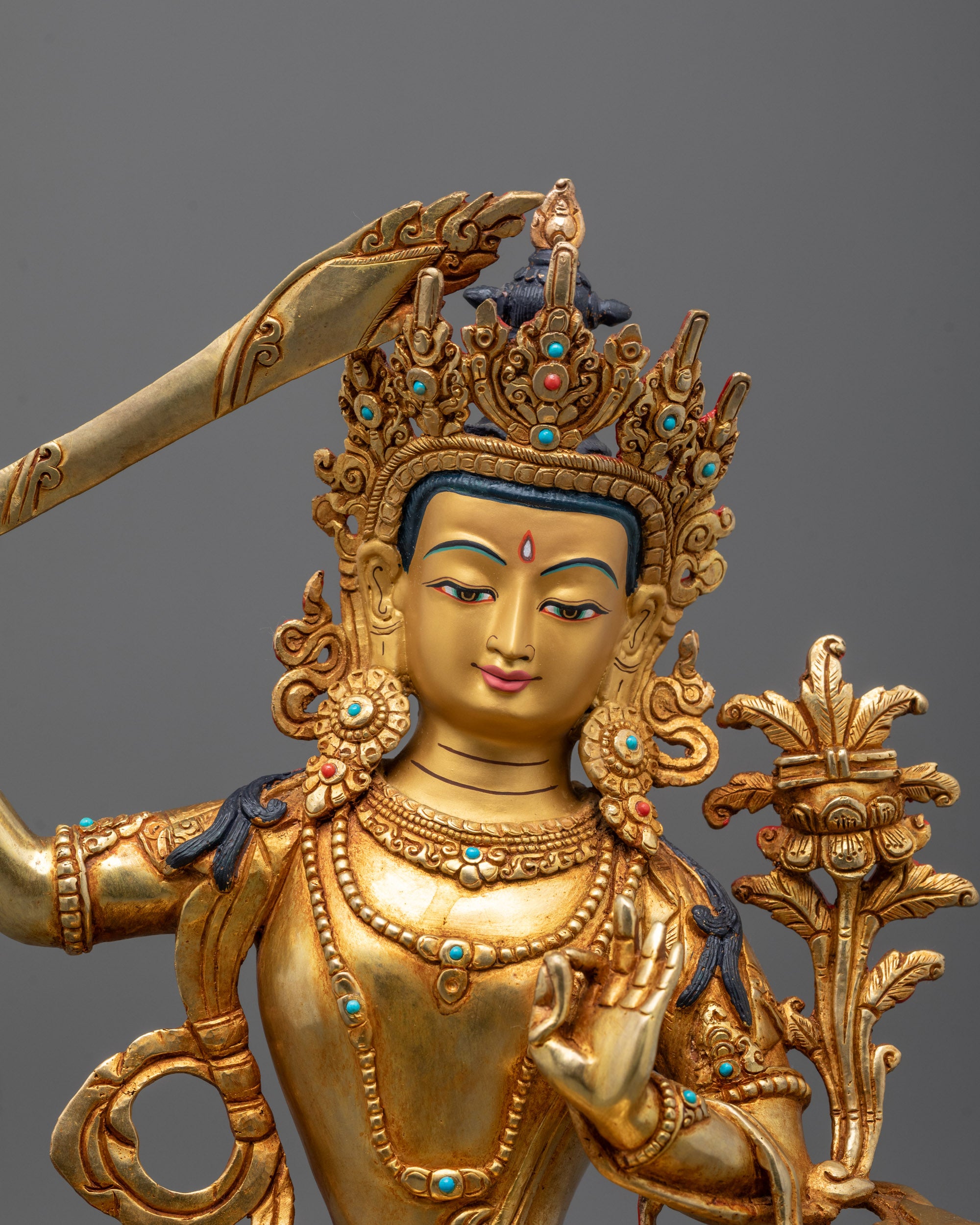 Close-up of Manjushri face with 24k fire gold gilded copper and intricate detailing