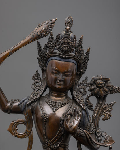 Close-up of Manjushri statue’s jeweled crown, wisdom sword, and sacred scripture