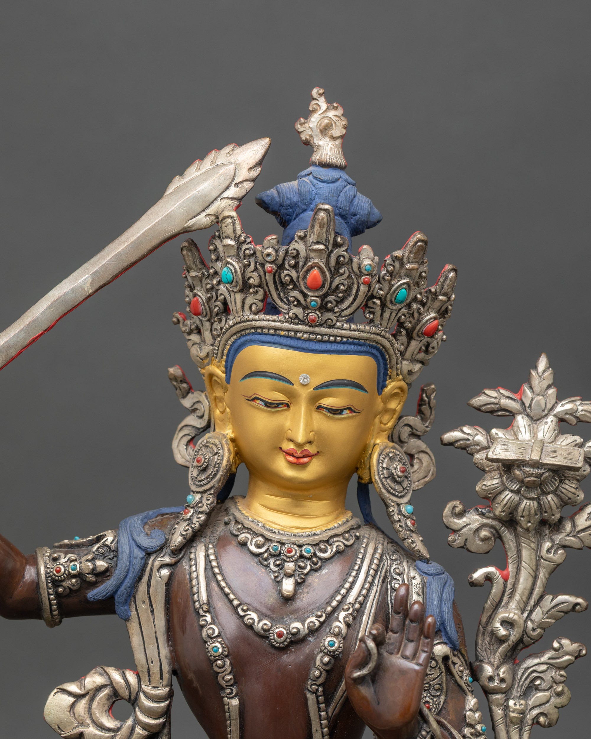 Close-up of Manjushri statue showing copper texture and semi-precious details