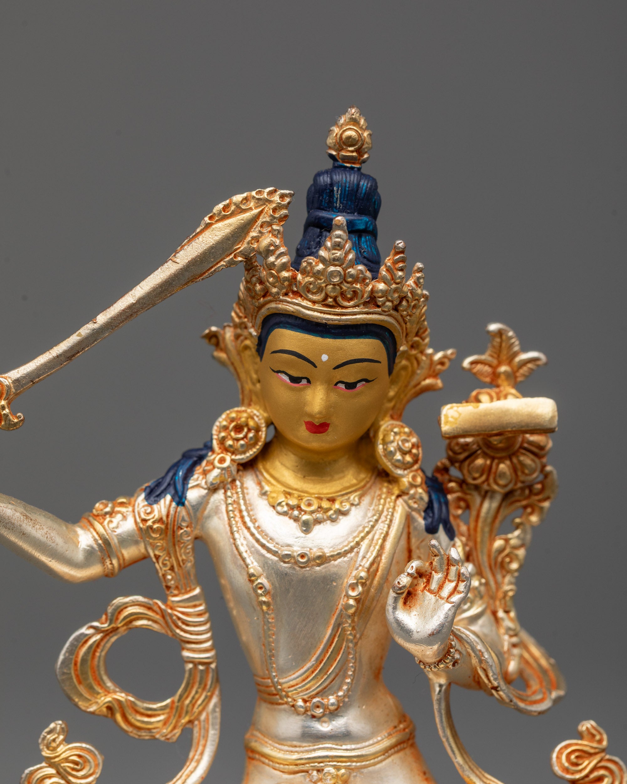 Close-up of Manjushri statue with five-jeweled crown and serene expression