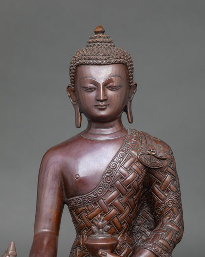 Close-up of Medicine Buddha face showing copper details and serene expression