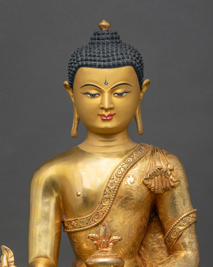 Close-up of Medicine Buddha face showing peaceful gold-painted expression