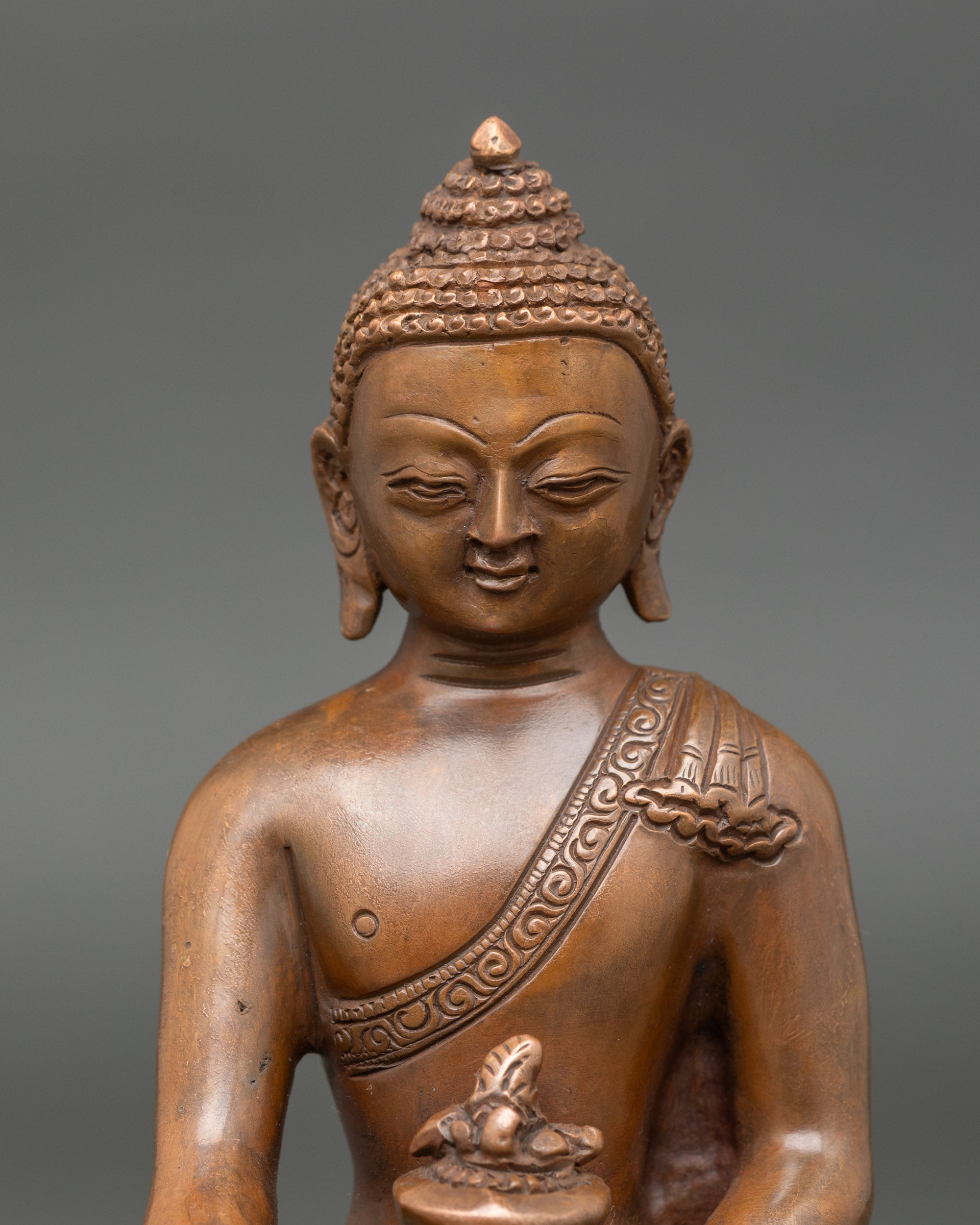 Close-up of Medicine Buddha face, showing serene expression and detailed craftsmanship