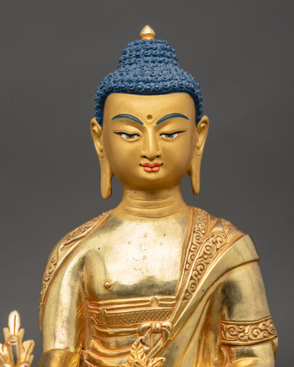 Close-up of Medicine Buddha face with serene expression and gold-painted details