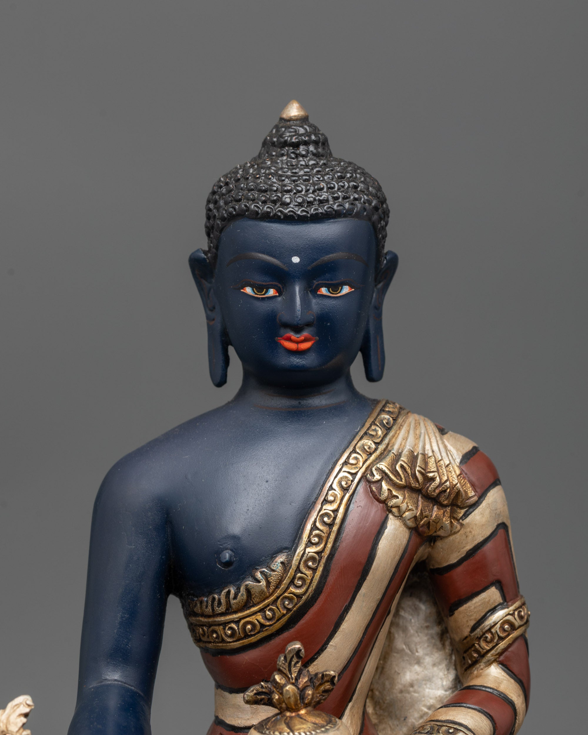 Close-up of Medicine Buddha holding monk’s bowl and myrobalan plant stem
