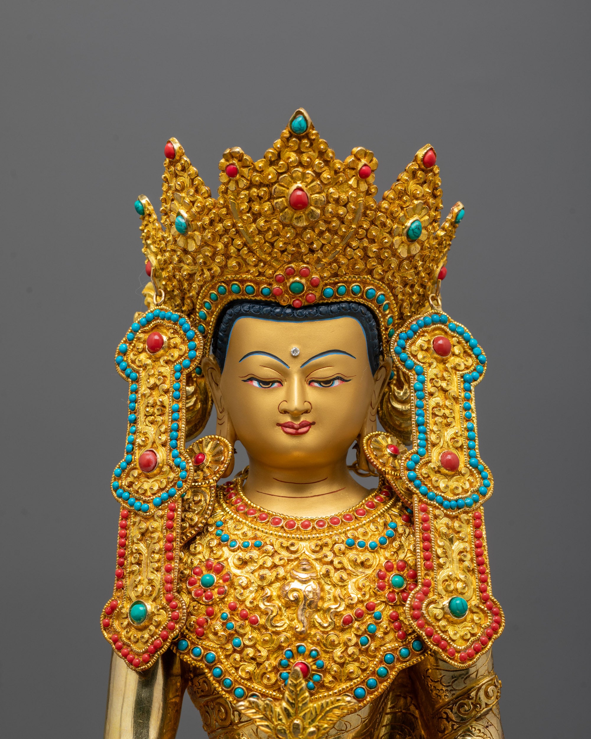 Close-up of Medicine Buddha’s crown, turquoise coral inlay, and serene facial expression
