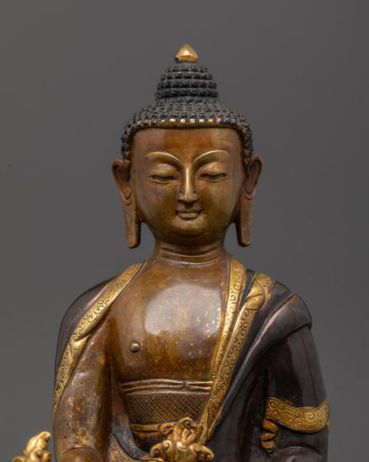 Close-up of Medicine Buddha’s gold-plated hands holding the healing myrobalan fruit