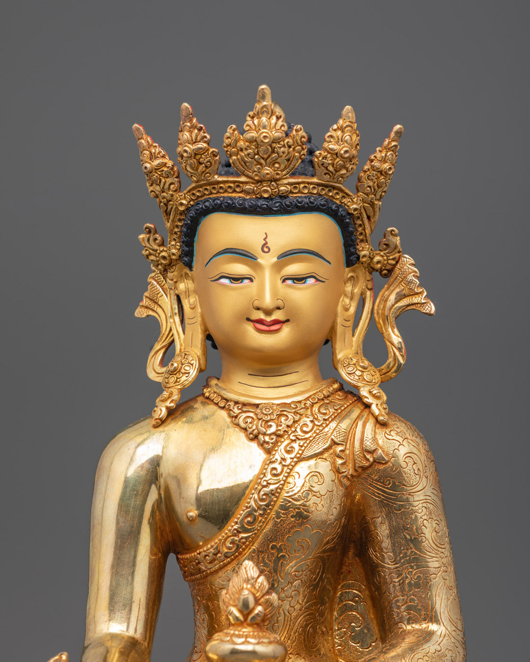 Close-up of Medicine Buddha’s hand holding nectar and Myrobalan plant in Varada mudra pose
