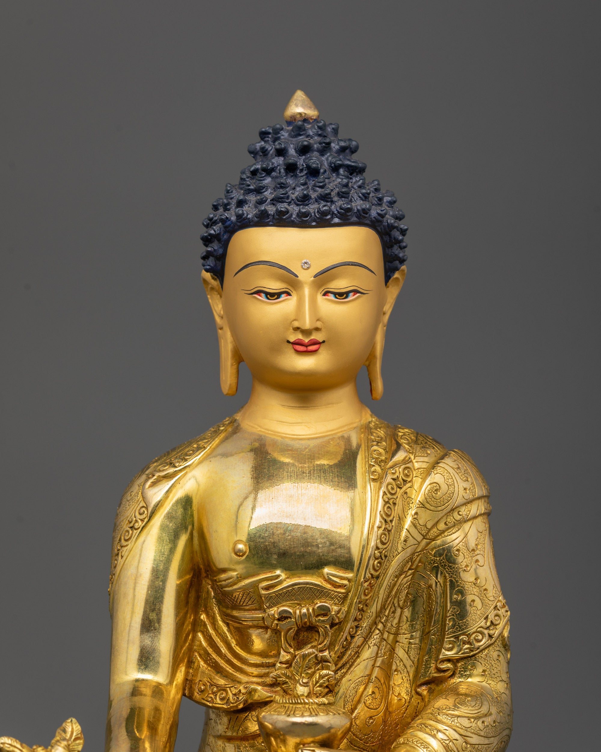 Close-up of Medicine Buddha’s hands holding sacred medicine herb and monk’s bowl