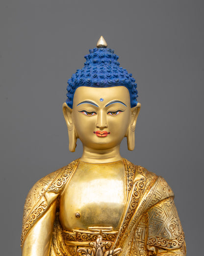 Close-up of Medicine Buddha’s serene gilded face and right hand holding a healing herb