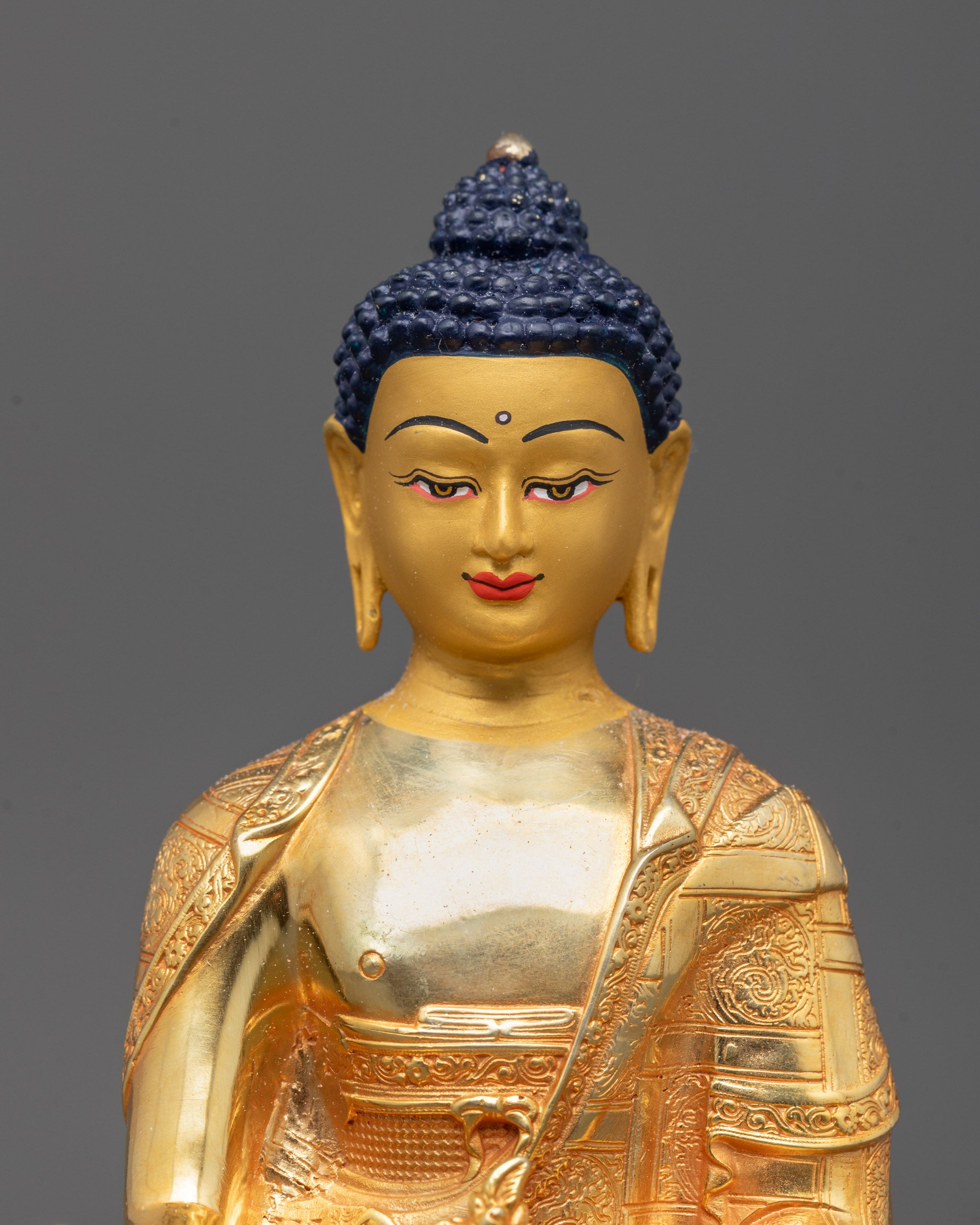 Close-up of Medicine Buddha statue showing intricate detailing on the monk’s bowl
