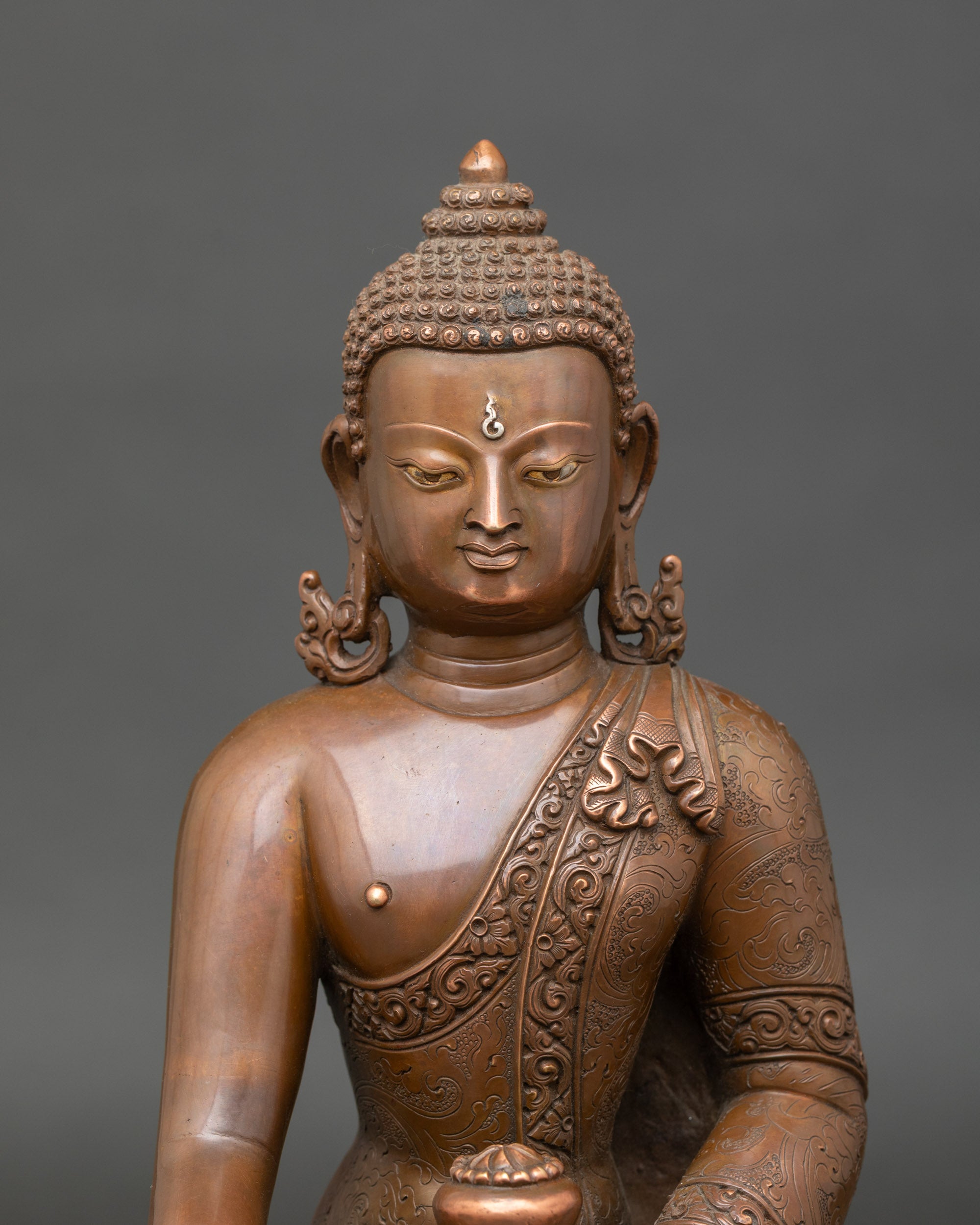 Close-up of Nepalese Buddha sculpture with monk's bowl and oxidized copper finish