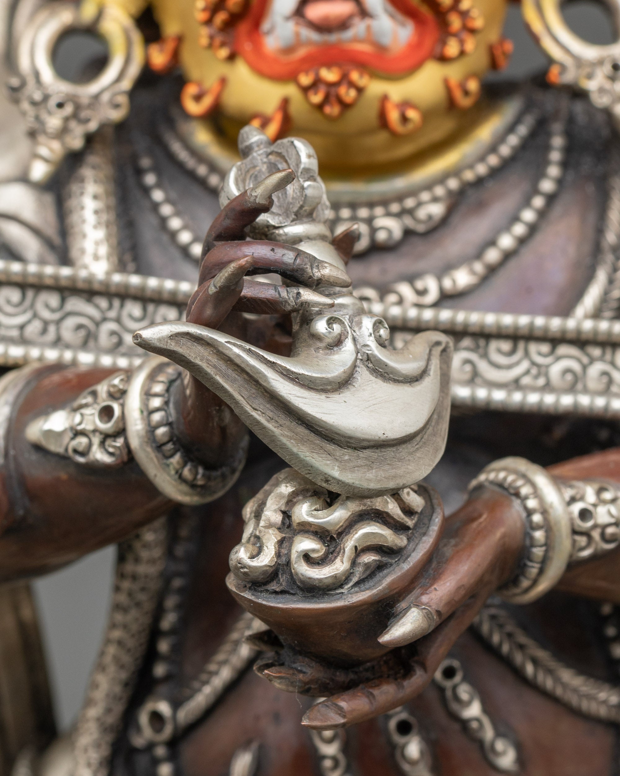 Close-up of Sakya Mahakala copper statue showing knife, skull cup, and flame details