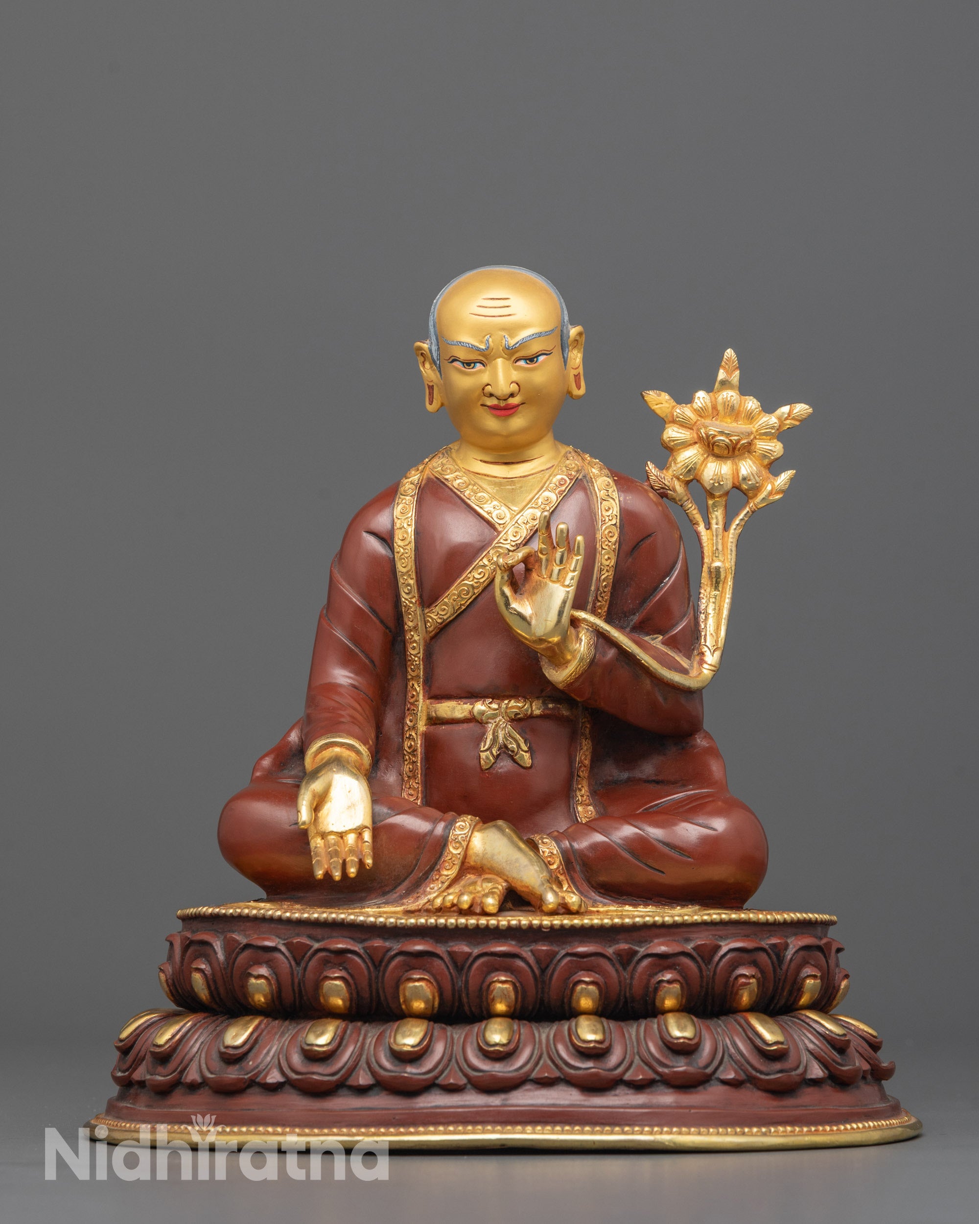 Close-up of Sakya Pandita statue face with Dharmachakra mudra and utpala flower