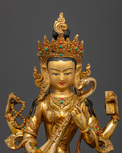 Close-up of Saraswati statue showing intricate veena and book details in gold finish