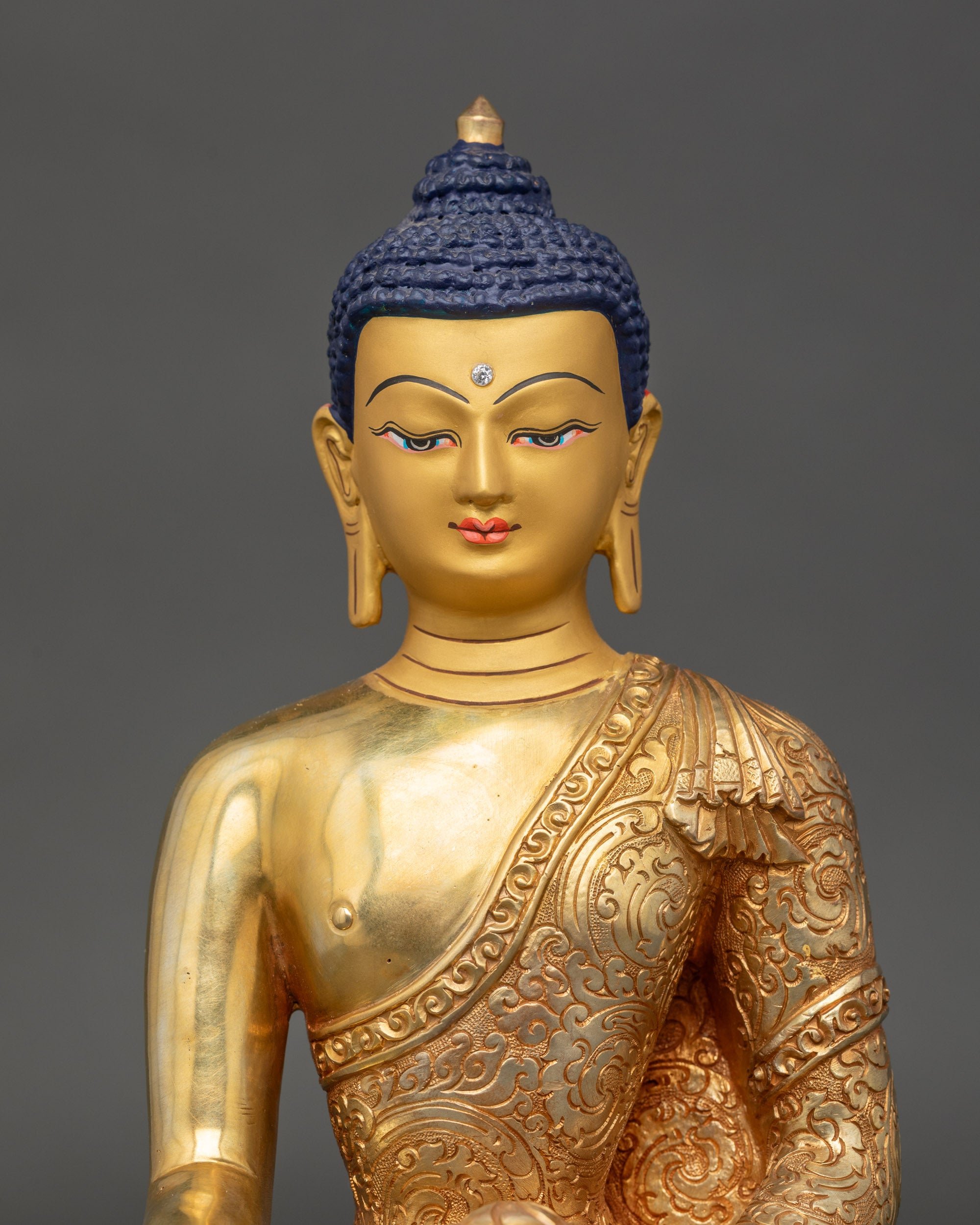 Close-up of Shakyamuni Buddha face showing gold-painted details and intricate carvings