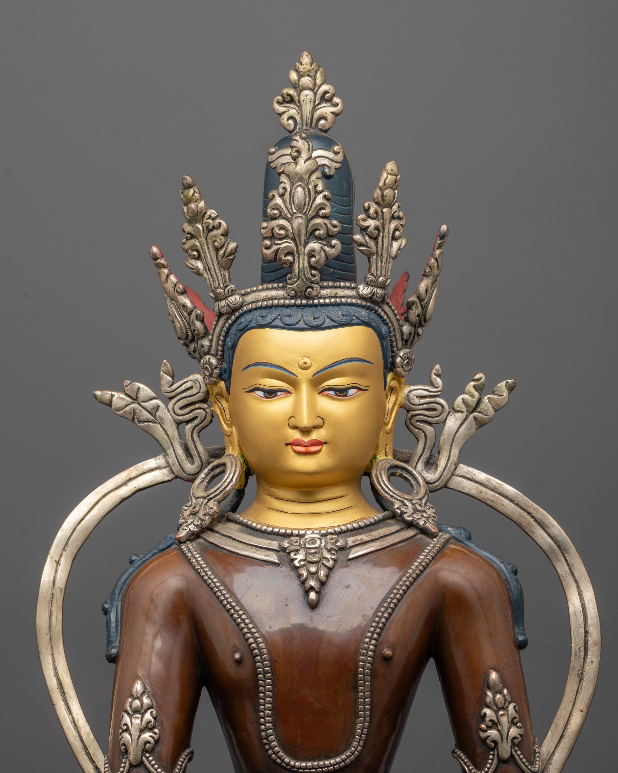 Close-up of Shakyamuni Buddha face showing gold gilding and intricate crown detail