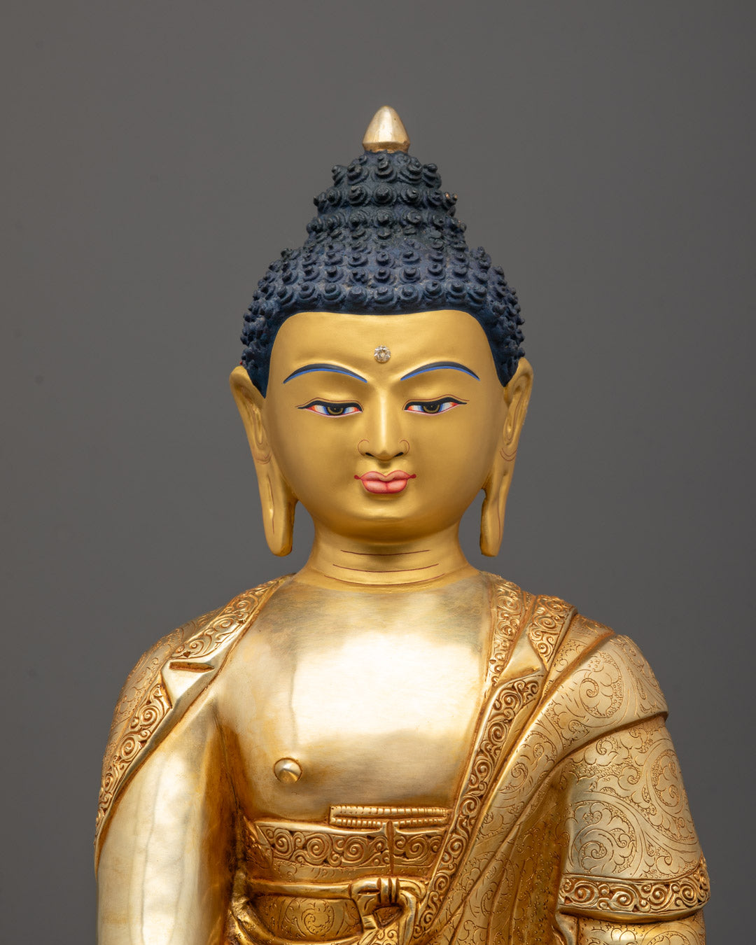 Close-up of Shakyamuni Buddha face showing peaceful expression and gold detailing