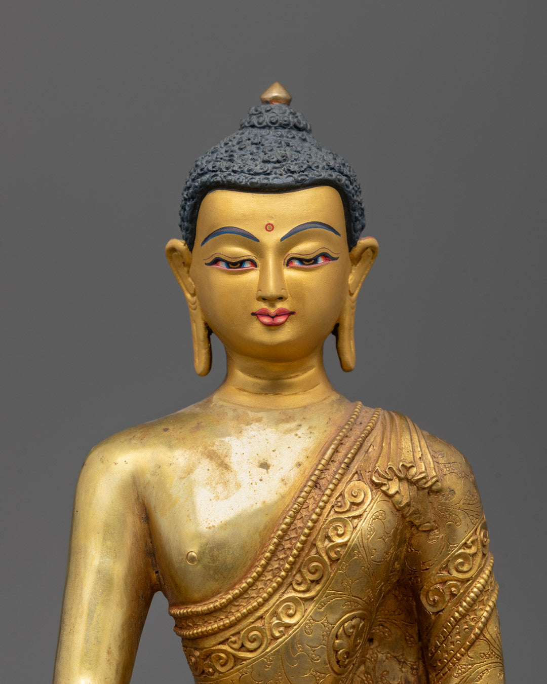 Close-up of Shakyamuni Buddha face with gold gilding and detailed craftsmanship