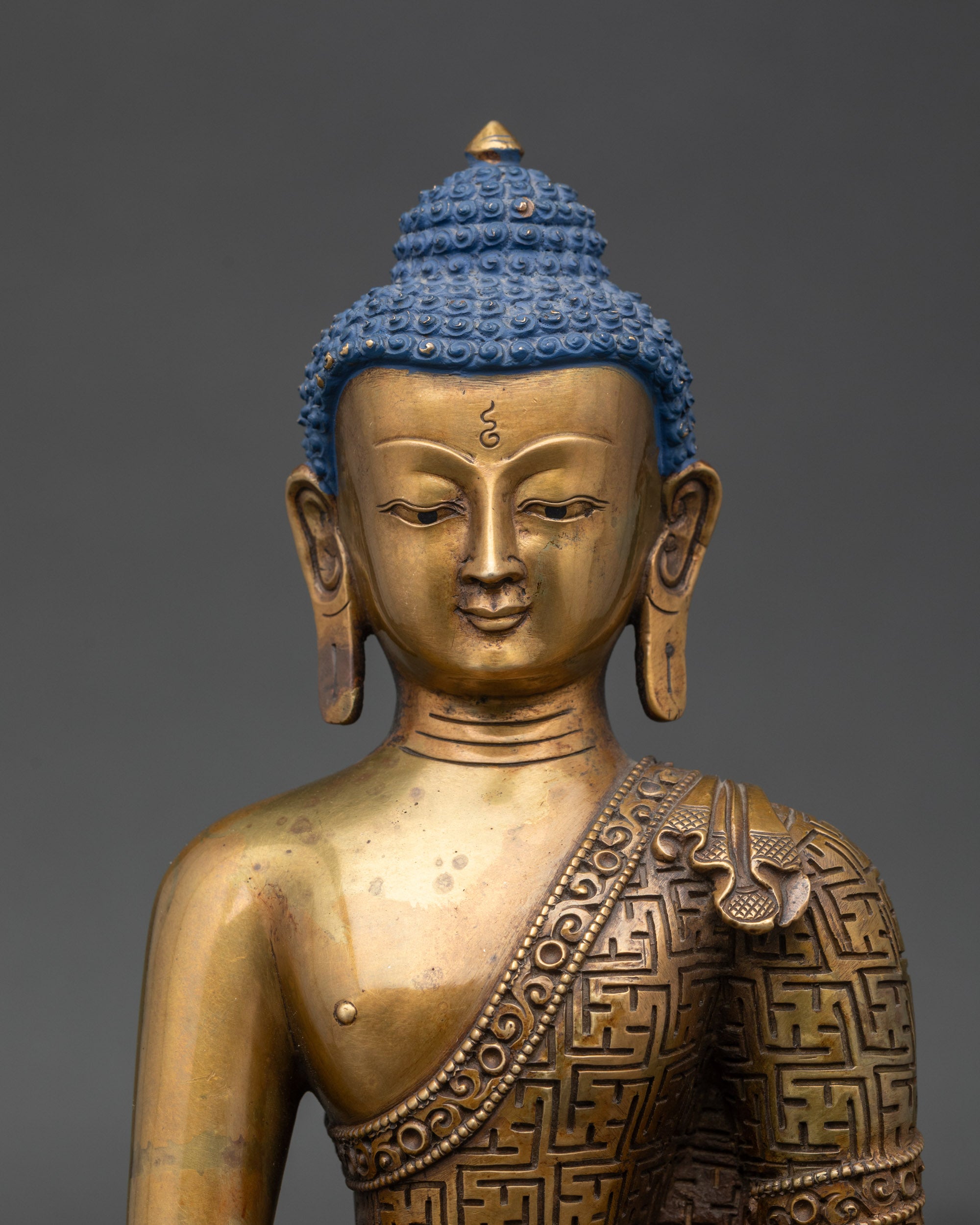 Close-up of Shakyamuni Buddha meditation statue showing detailed copper carvings