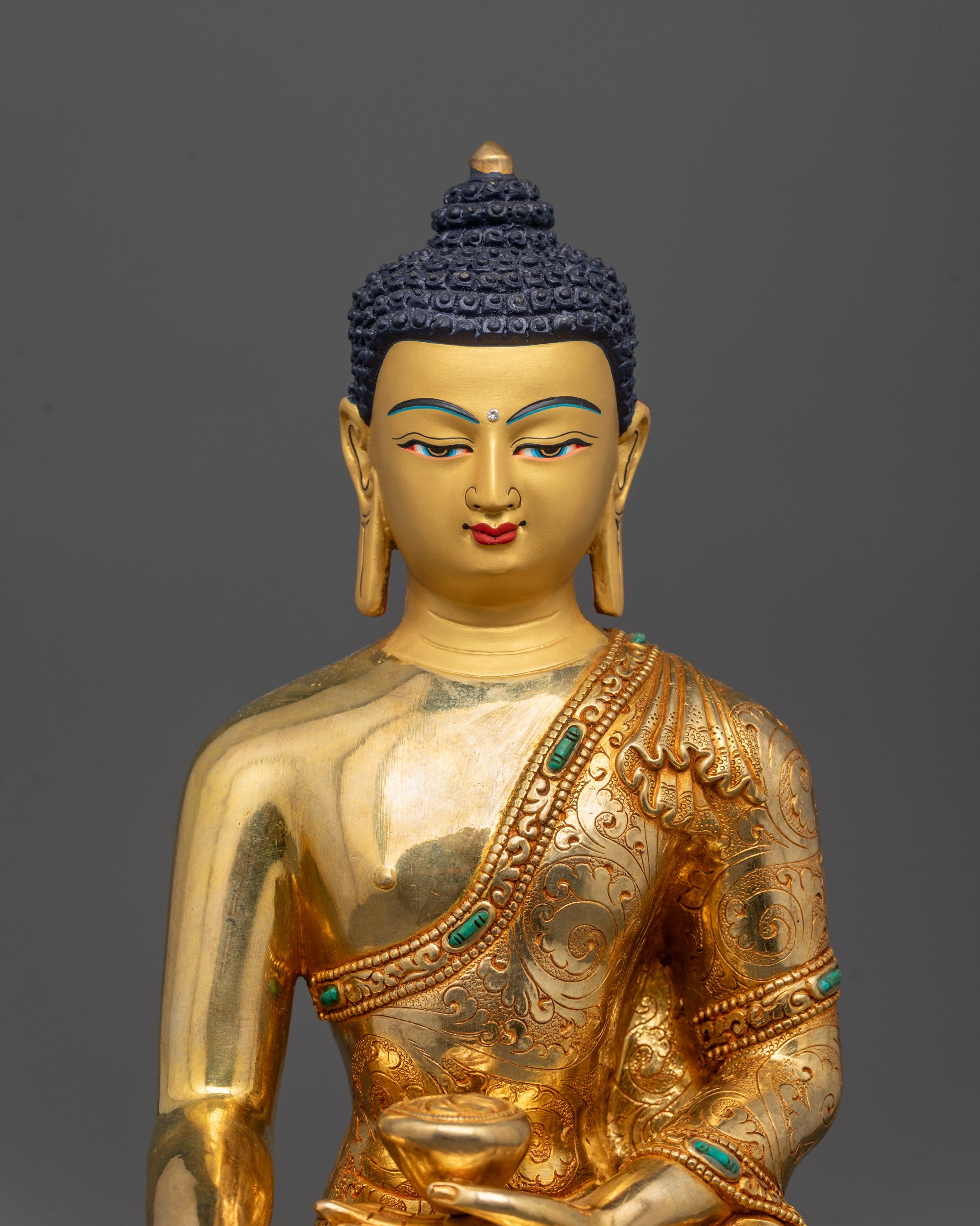 Close-up of Shakyamuni Buddha’s calm face and hand in bhumisparsha mudra