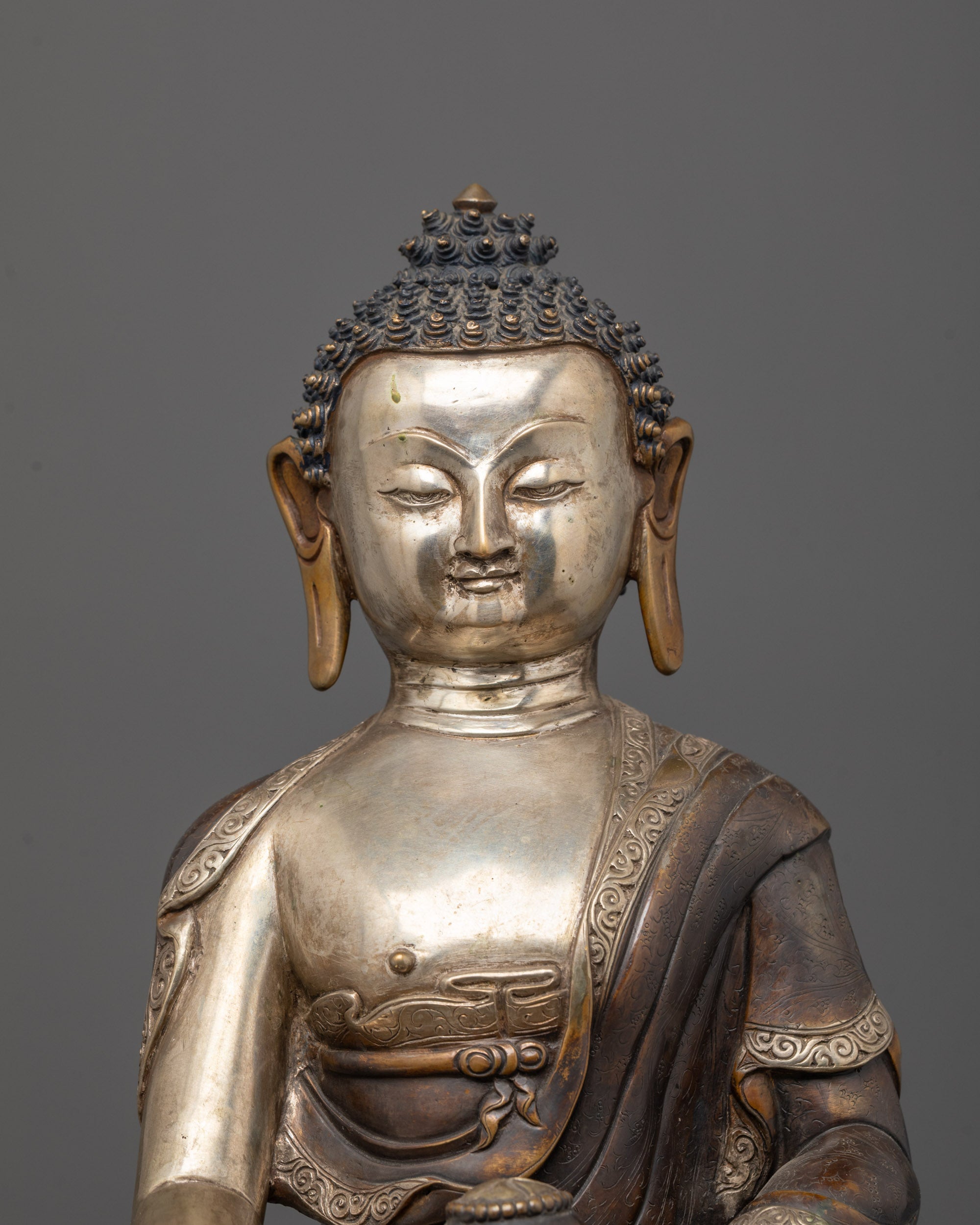 Close-up of Shakyamuni Buddha’s serene face and monk’s bowl