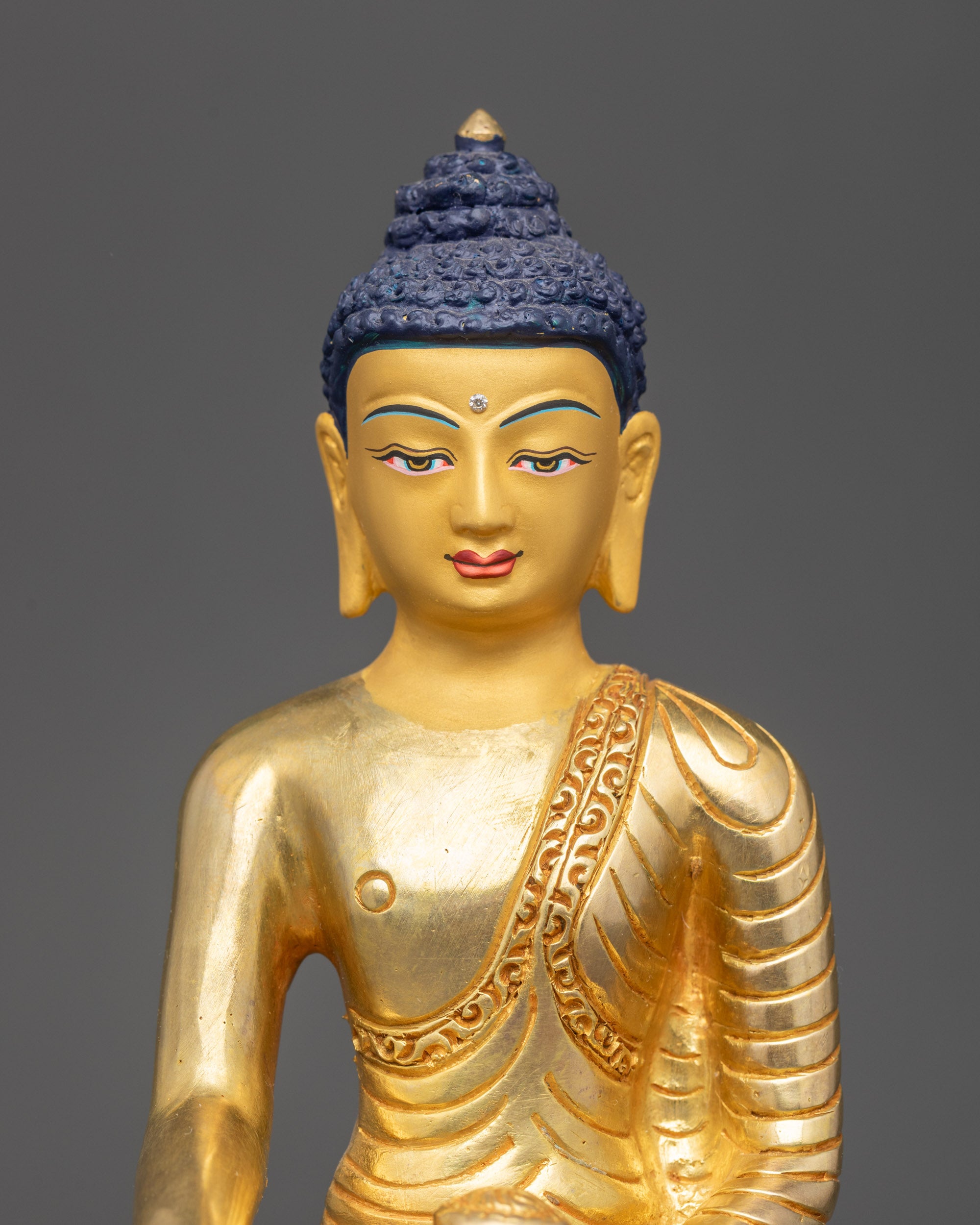 Close-up of Shakyamuni Buddha’s serene face with gold fire-gilding details
