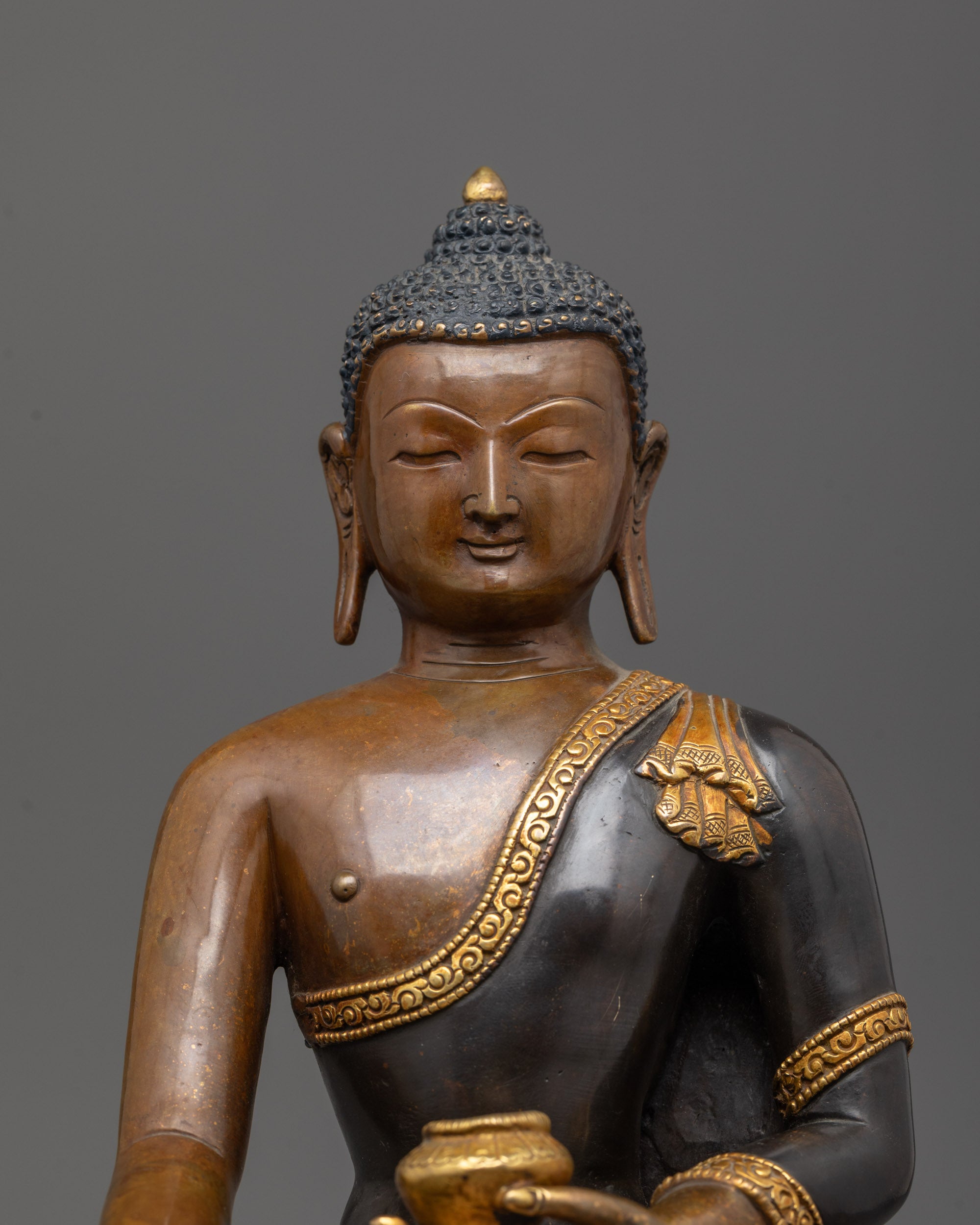 Close-up of Shakyamuni Buddha’s serene face with oxidized copper finish
