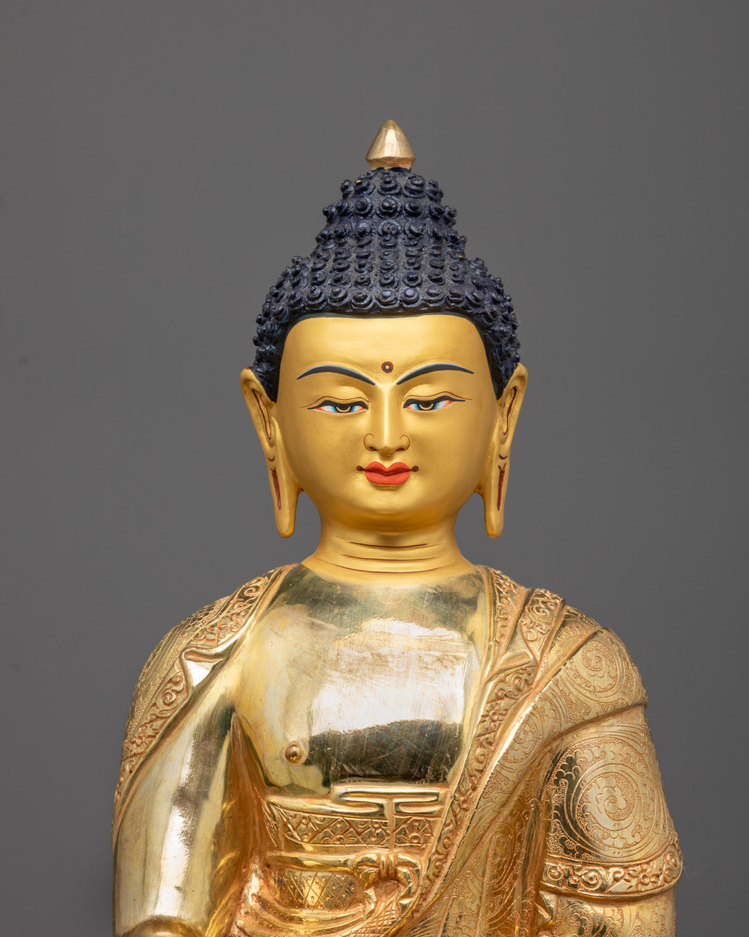 Close-up of Shakyamuni Buddha’s serene gold-gilded face 
