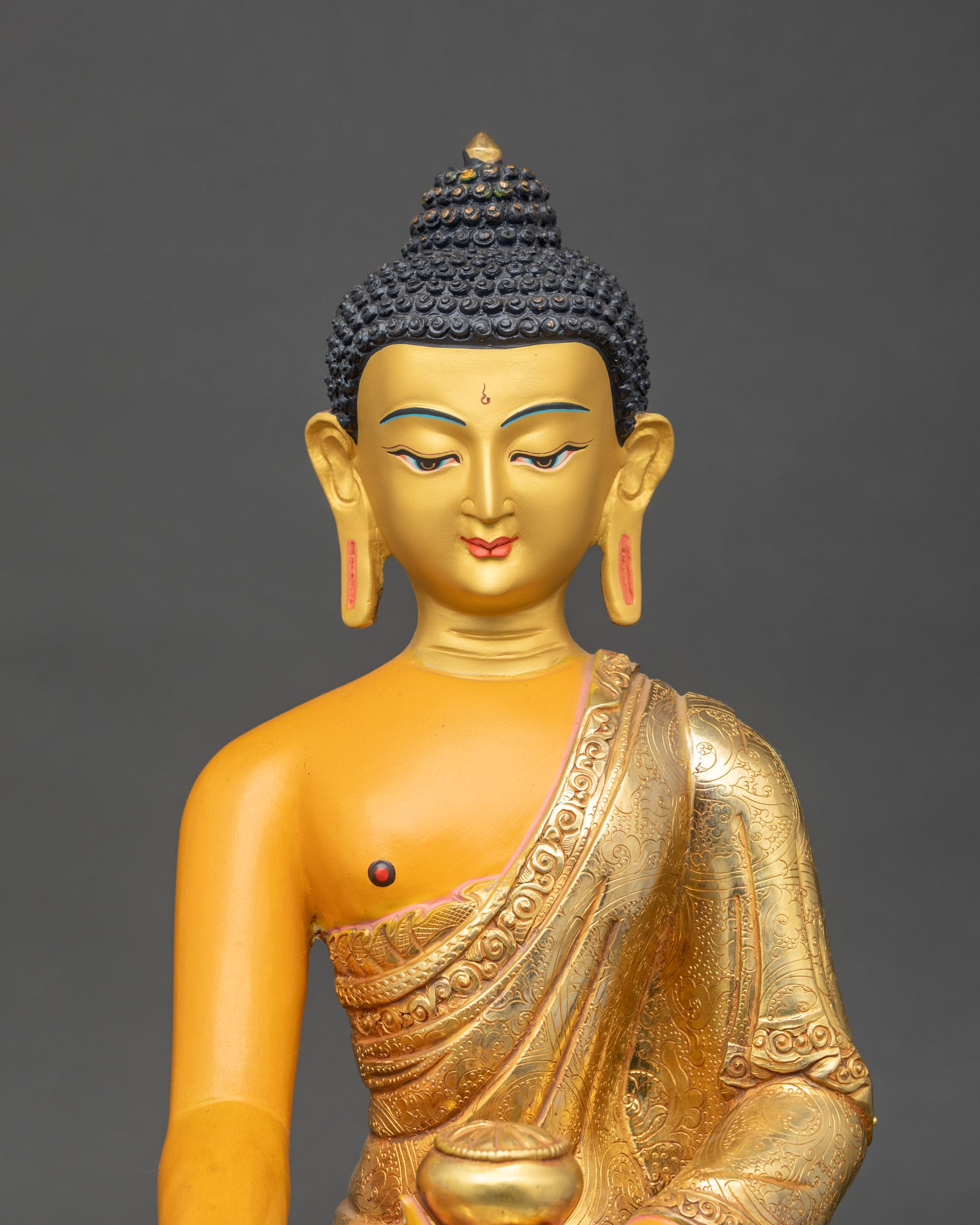 Close-up of Shakyamuni Buddha sculpture showing intricate acrylic color details and gold-painted face for meditation and home altar