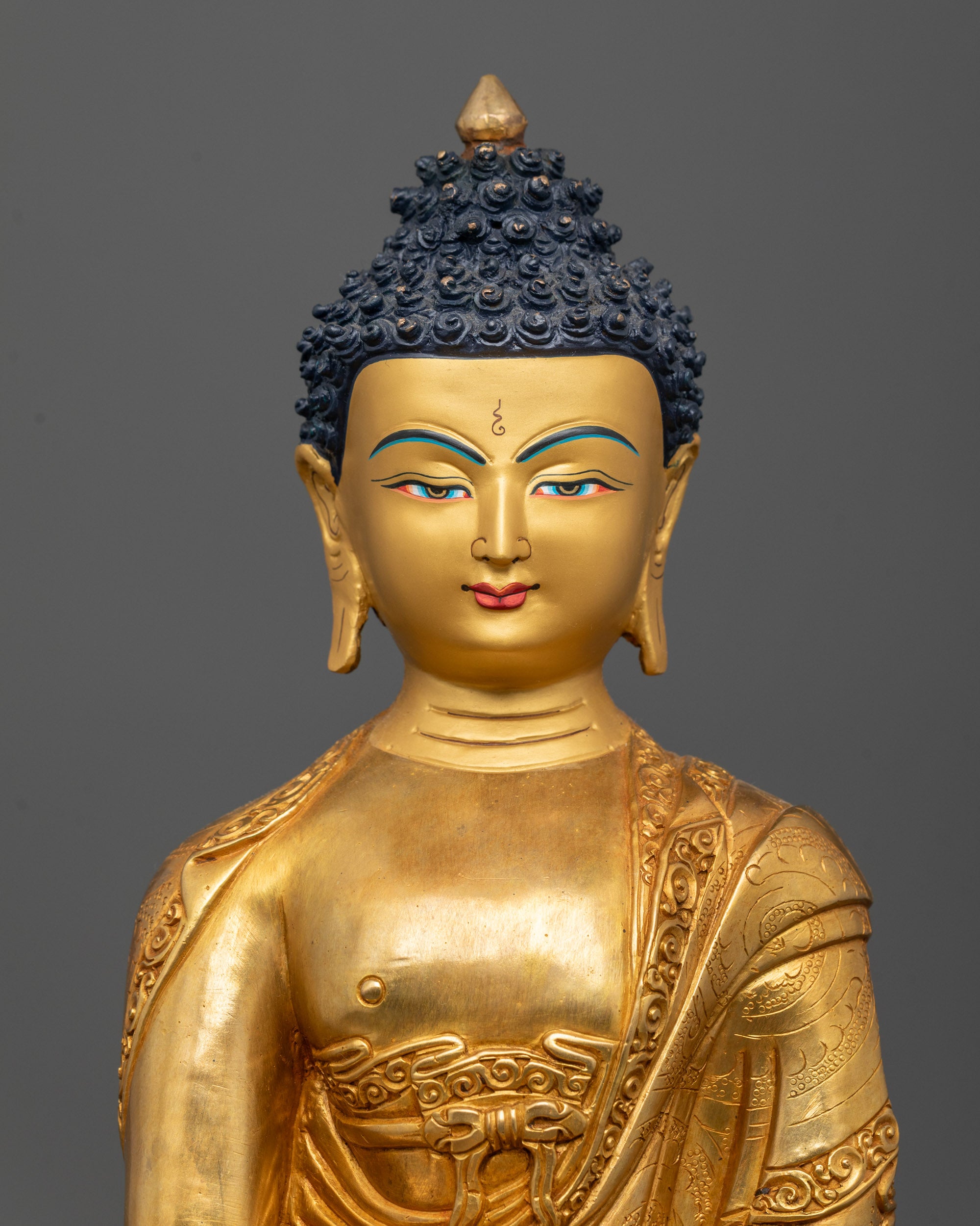 Close-up of Shakyamuni Buddha statue’s serene face and detailed bhumisparsha mudra hand