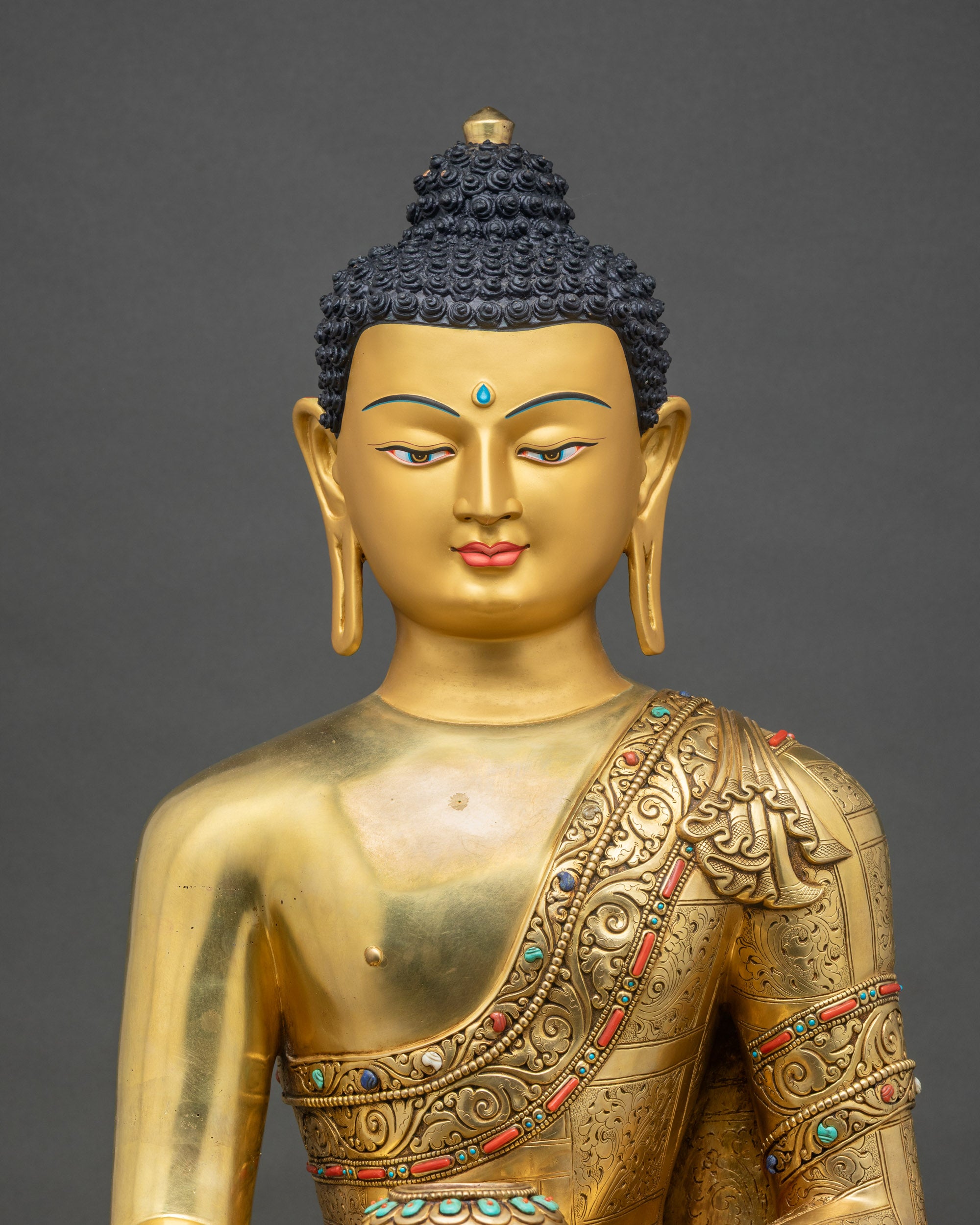Close-up of Shakyamuni Buddha statue showing gold fire-gilding and intricate lotus pedestal