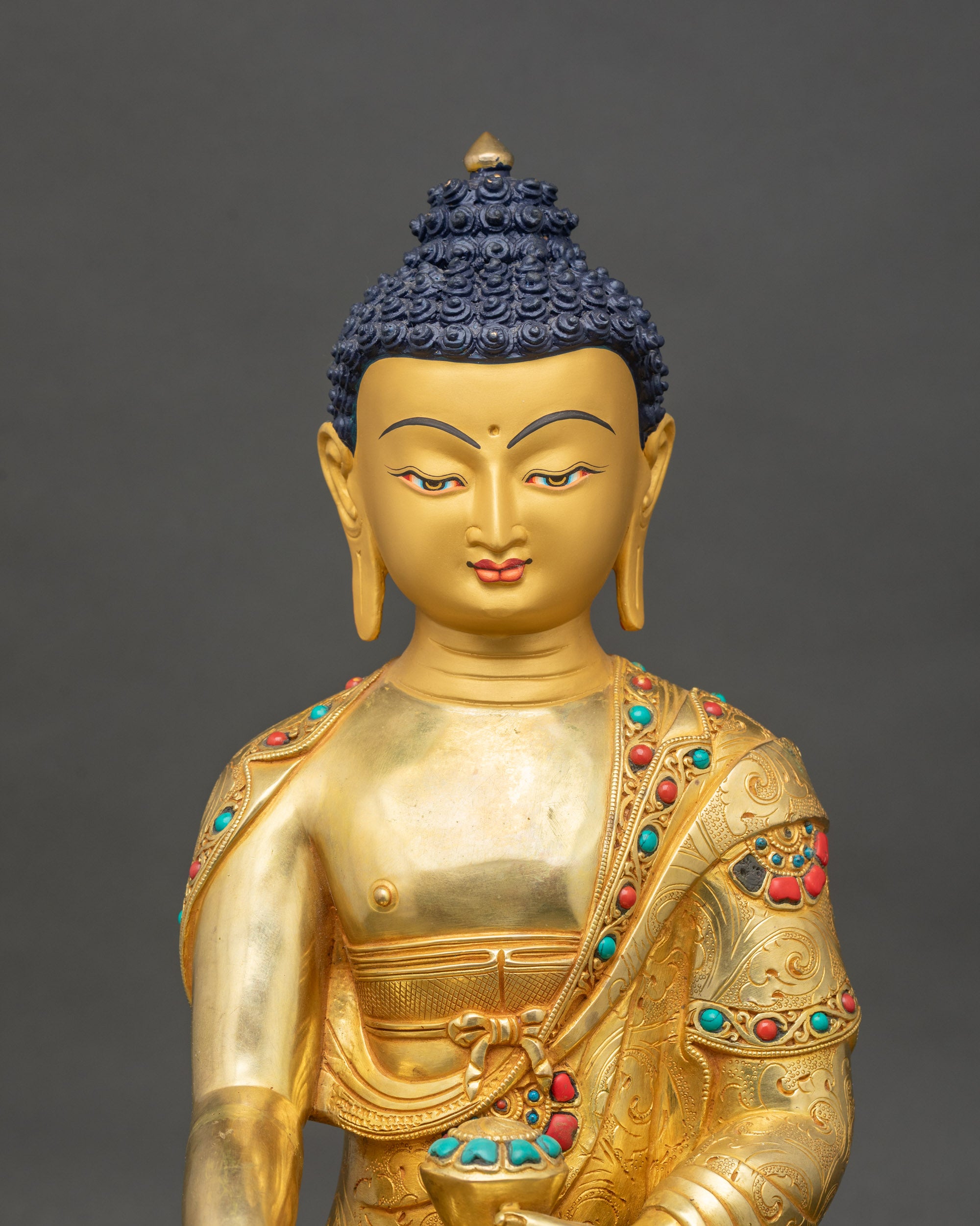 Close-up of Shakyamuni Buddha statue showing intricate copper and 24K gold details