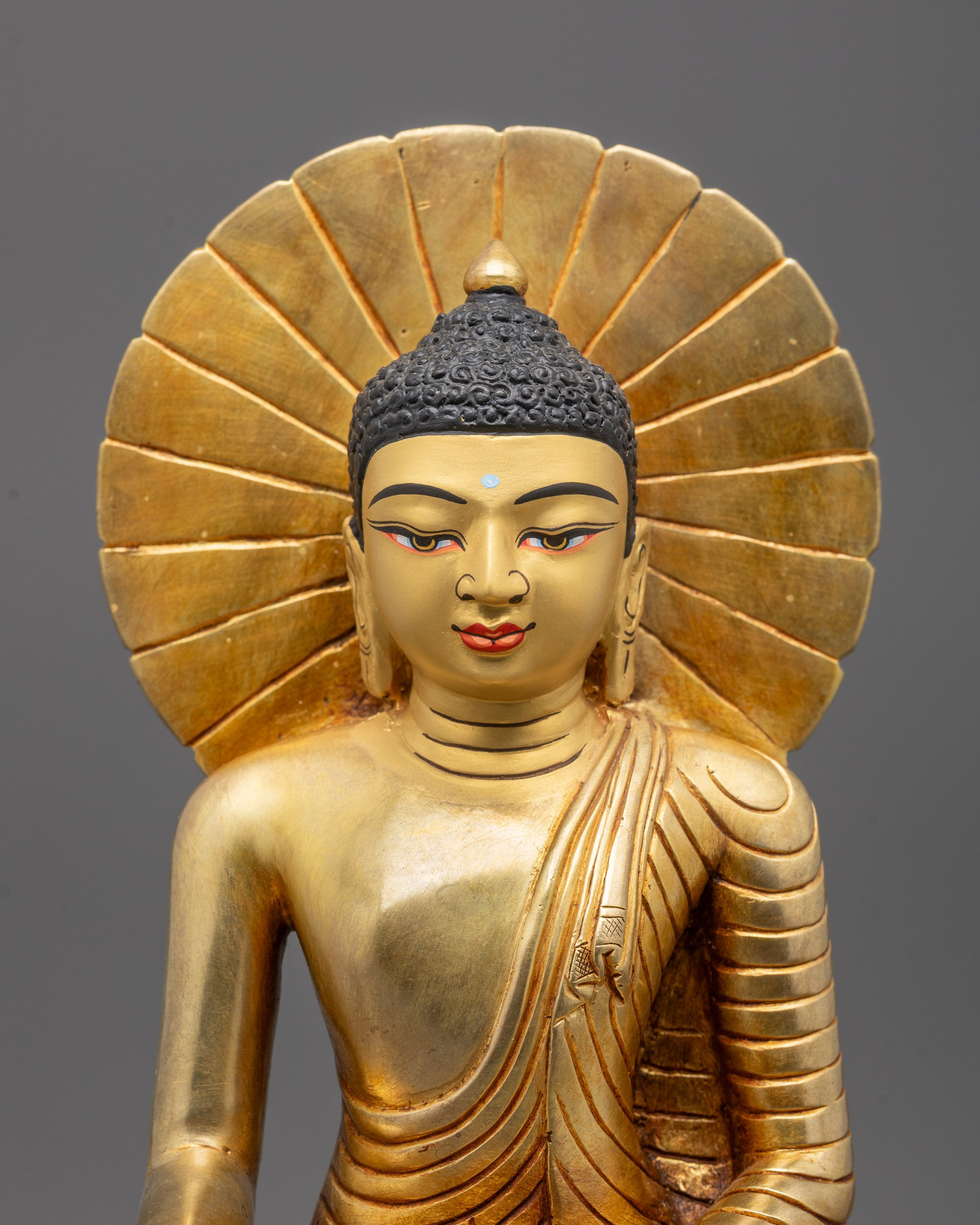 Close-up of Siddhartha Gautama statue featuring detailed halo and traditional copper craftsmanship.