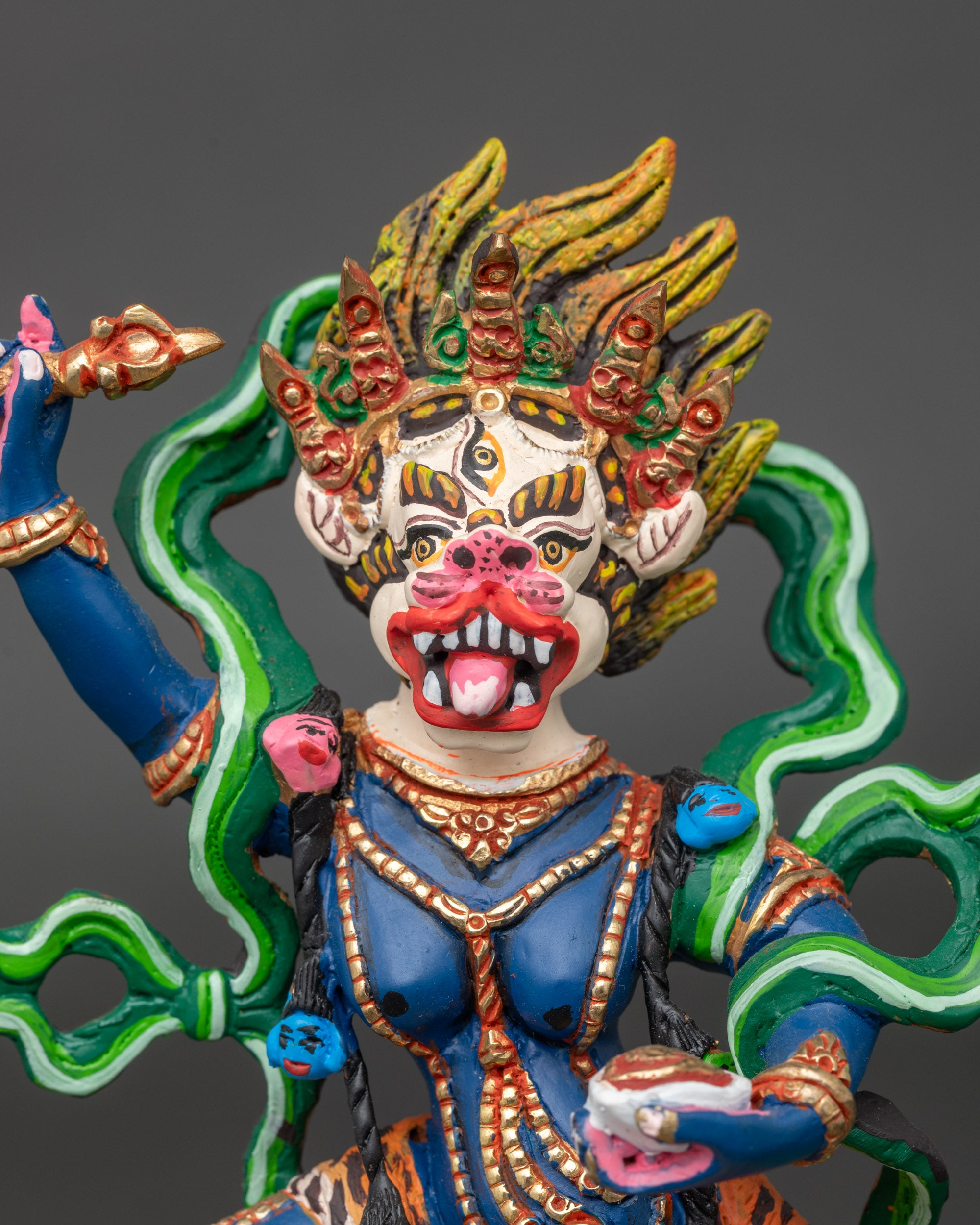 Close-up of Simha Mukha deity showing intricate details of flaying knife, kapala, and halo