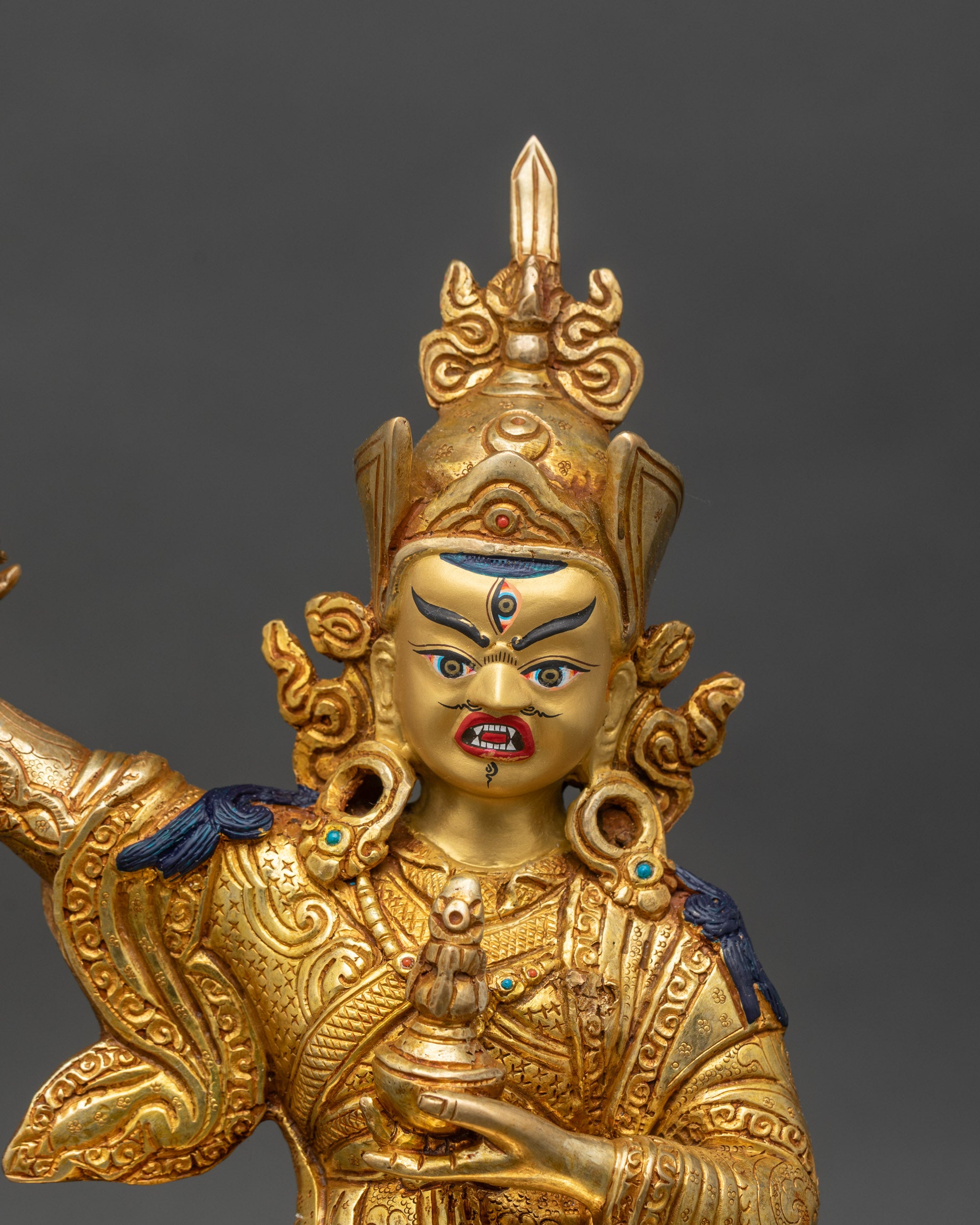 Close-up of Standing Guru Rinpoche statue – Detailed copper and gold craftsmanship showcasing sacred Buddhist artistry.