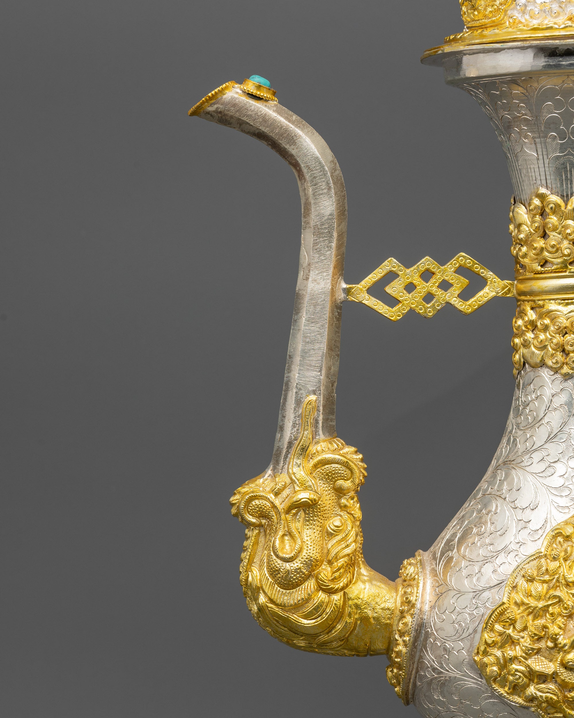 Close-up of Tea pot pouring spout with delicate filigree and auspicious lid detail