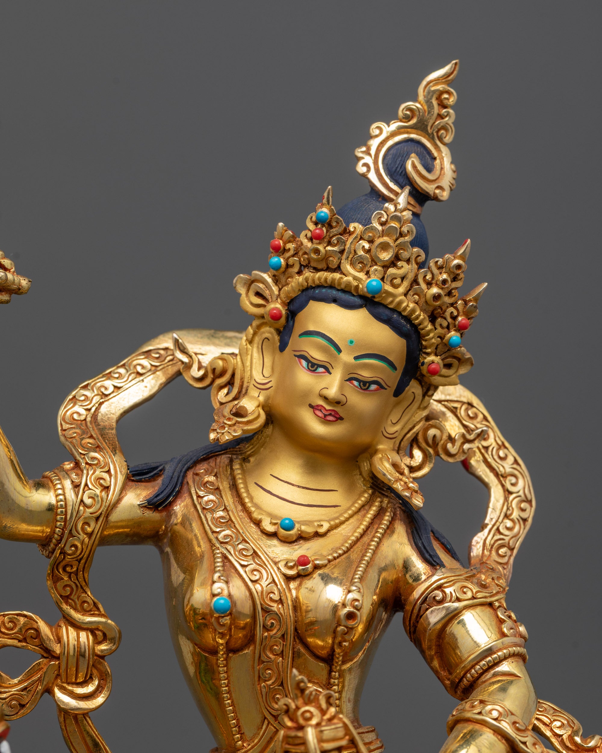 Close-up of Tsheringma’s face with intricate gold detailing, wearing a traditional headdress