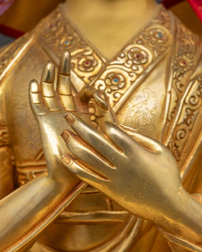 Close-up of Tsongkhapa's hands performing the Dharmachakra Mudra with blossoming utpala flowers