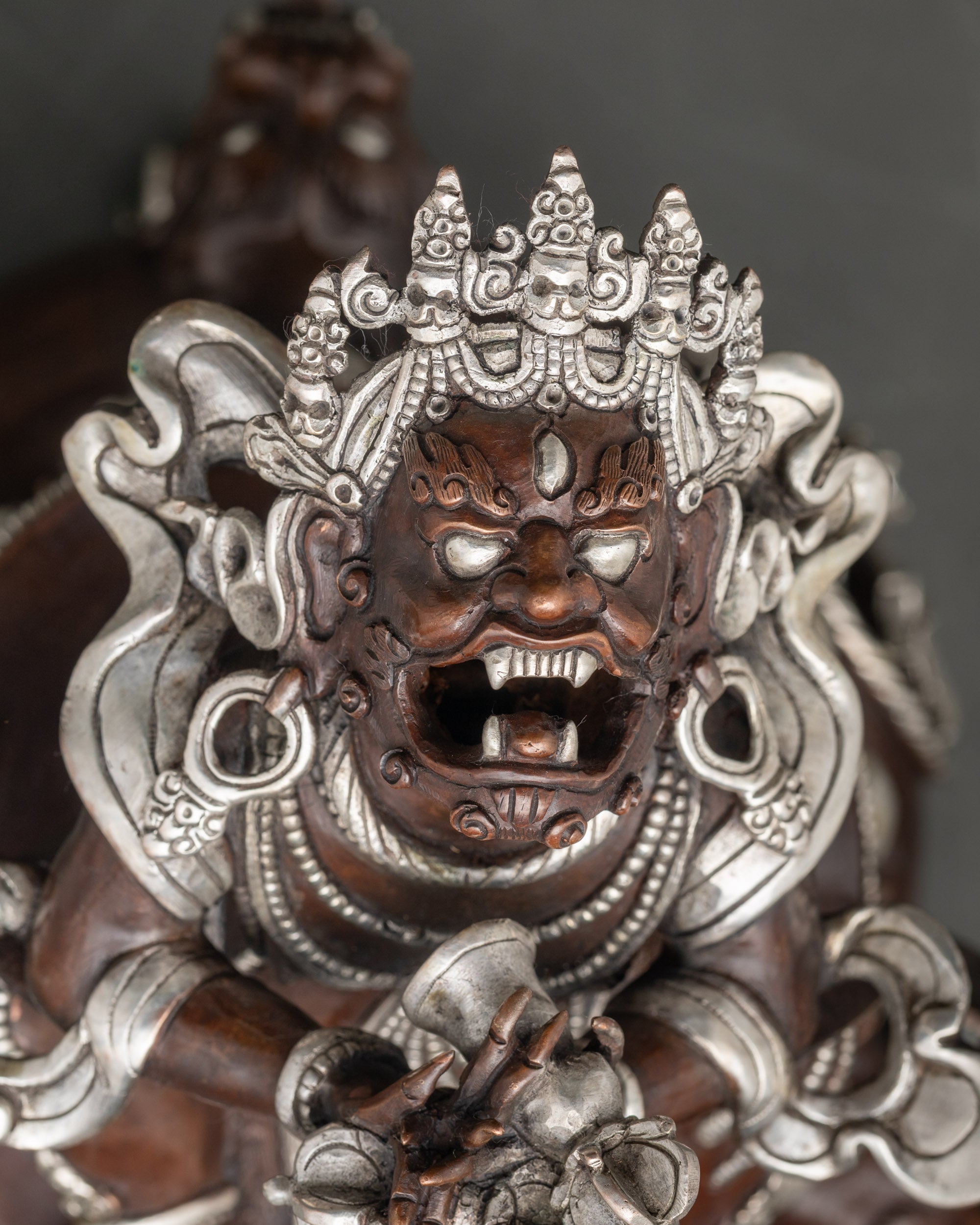 Close-up of Vajradhaka statue showing wrathful expression and fangs for spiritual empowerment