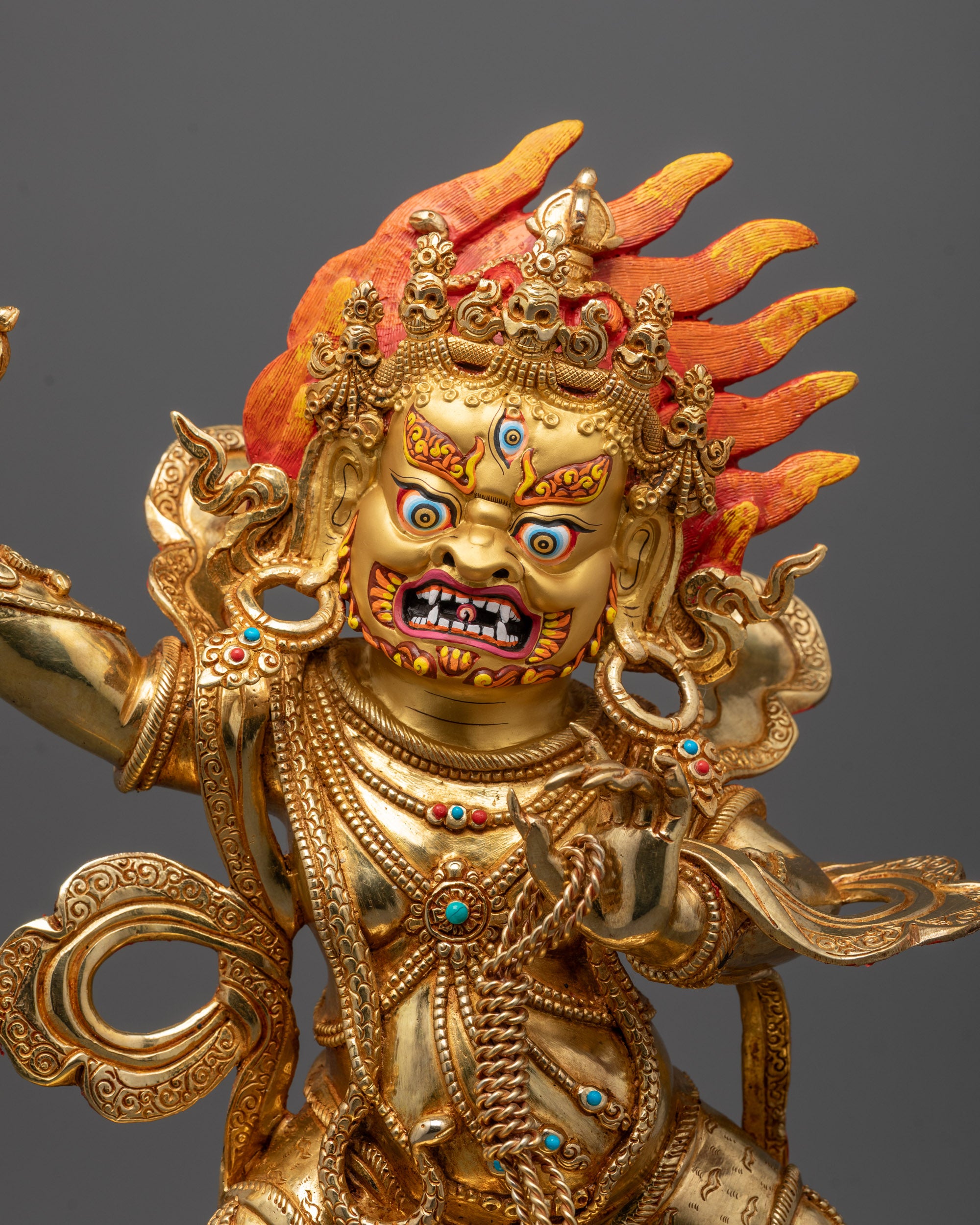 Close-up of Vajrapani Statue face showing 24K gold gilding and wrathful expression